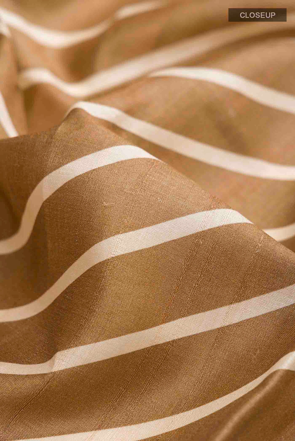 Close up of Green Tussar Silk Saree with Printed design on the body and Embroidery Border displaying folds
