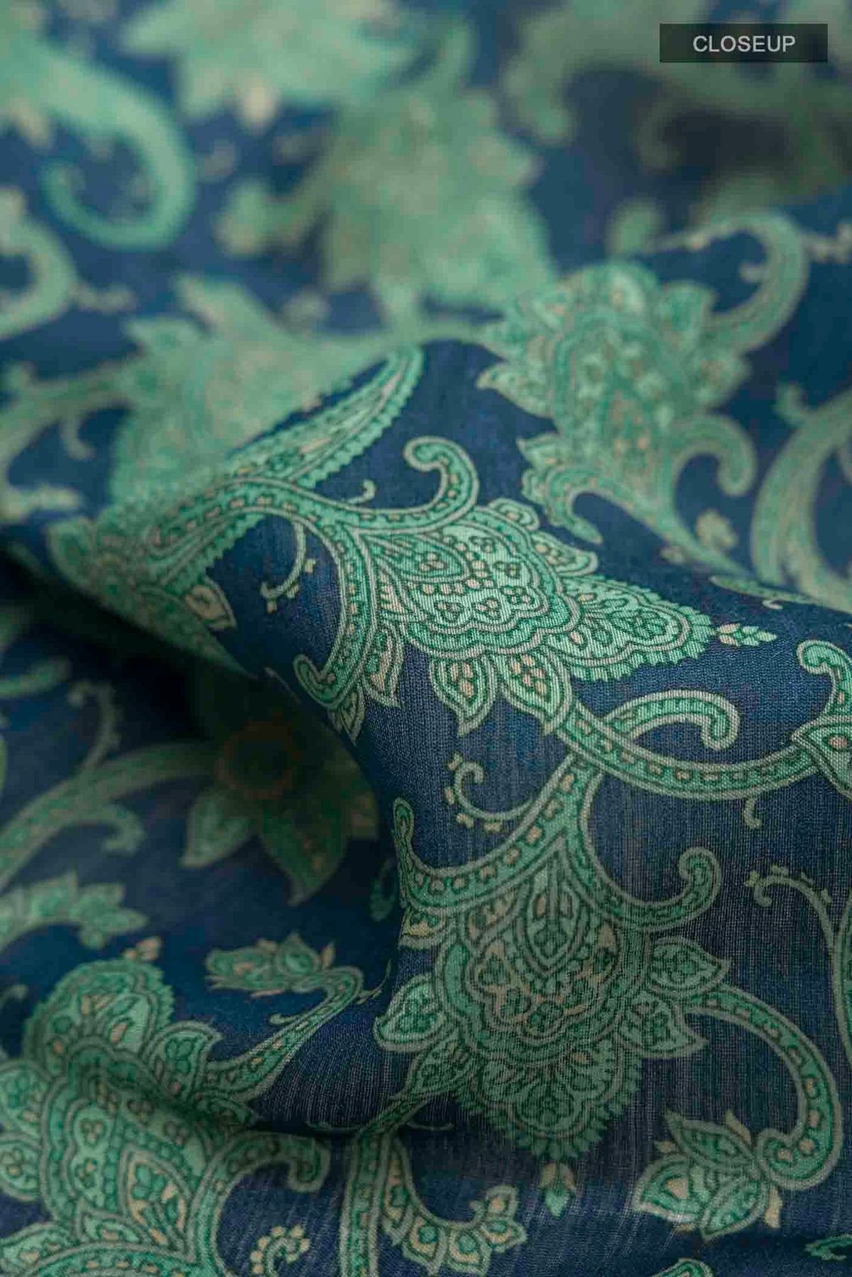 Close up of Blue Tussar Silk Saree with Printed design on the body and Zari And Thread Border displaying folds