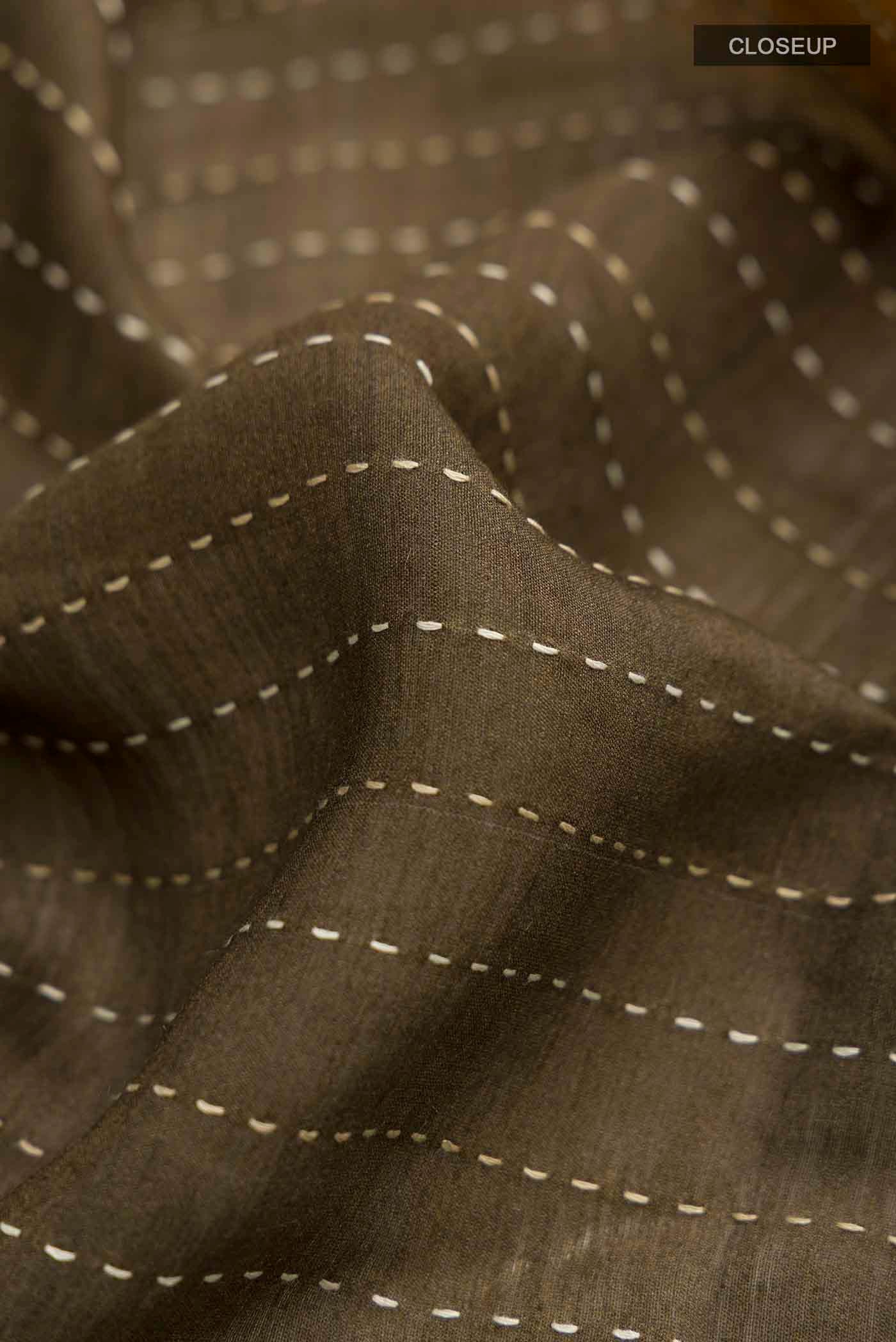 Close up of Green Tussar Silk Saree with Embroidery on the body and Zari Border displaying folds