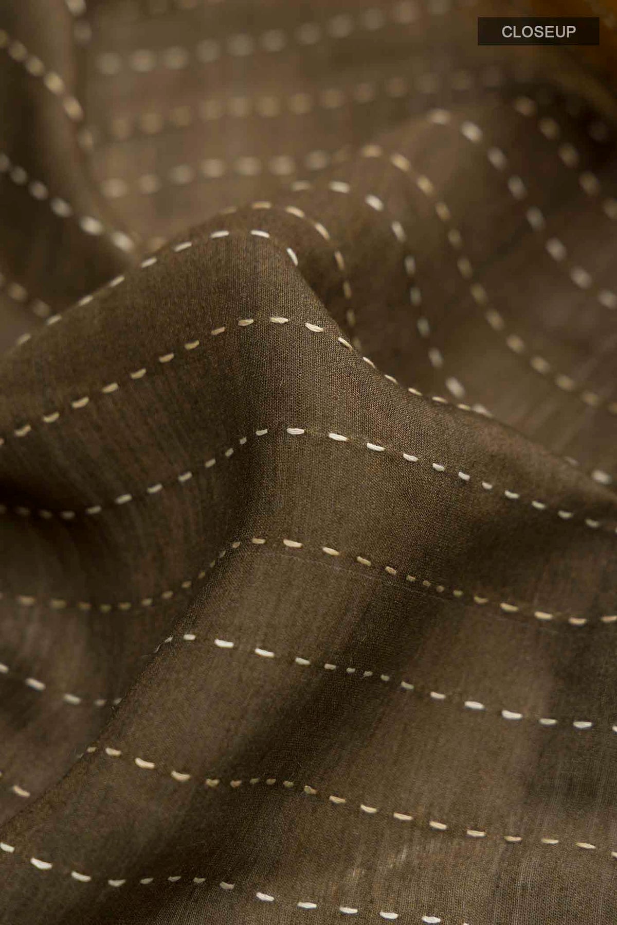 Close up of Green Tussar Silk Saree with Embroidery on the body and Zari Border displaying folds
