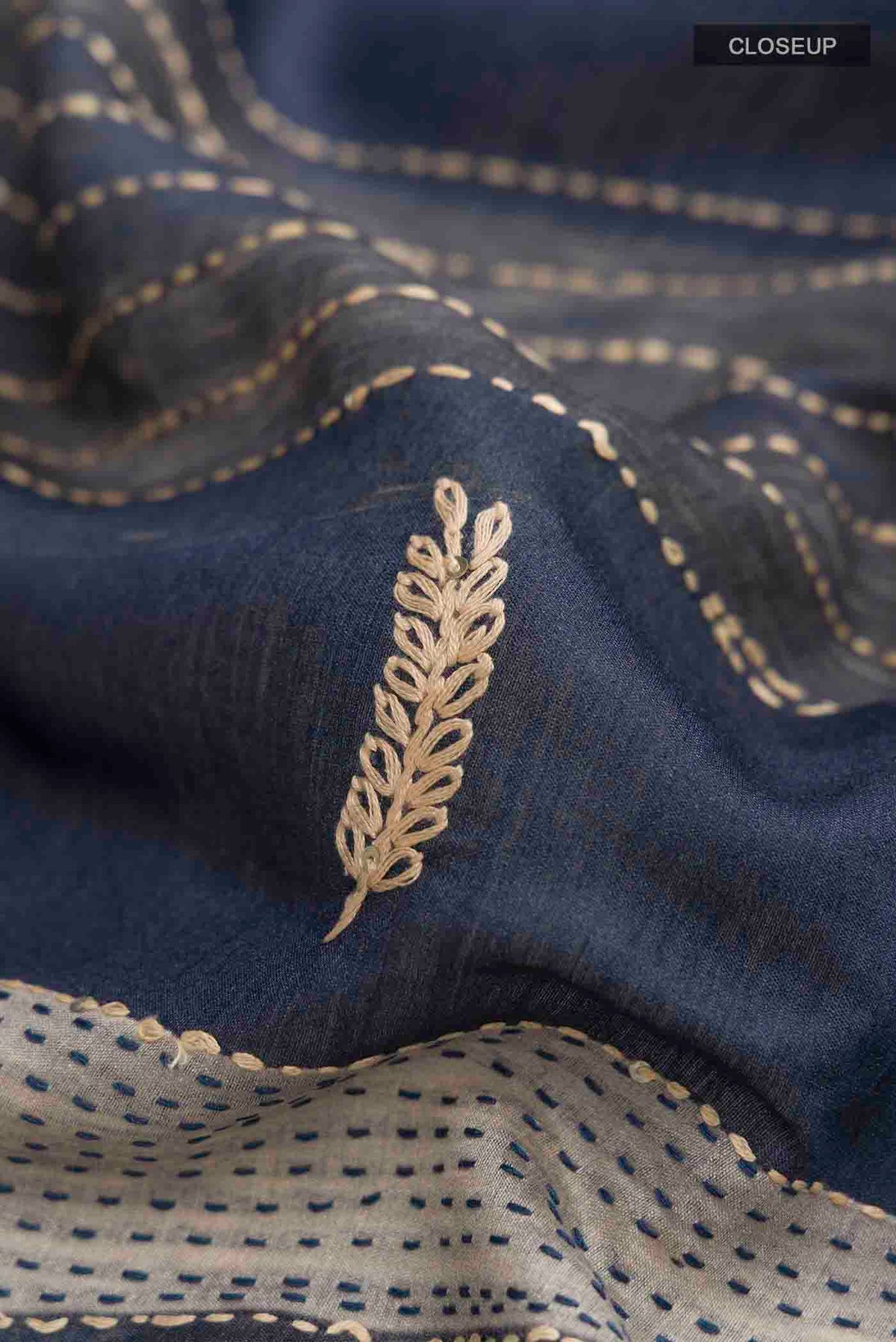 Close up of Maroon Tussar Silk Saree with Embroidery on the body and Zari Border displaying folds
