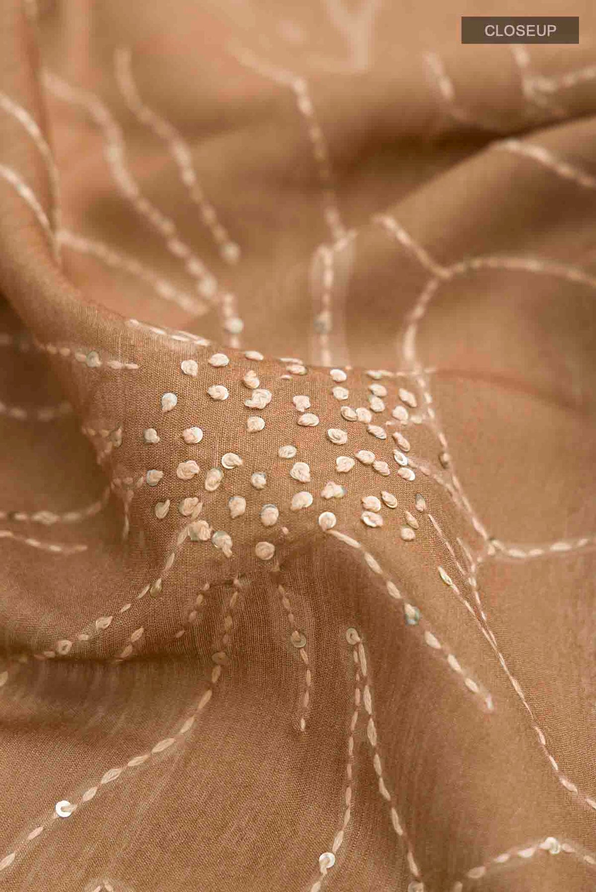 Close up of Green Tussar Silk Saree with Embroidery on the body and Zari Border displaying folds