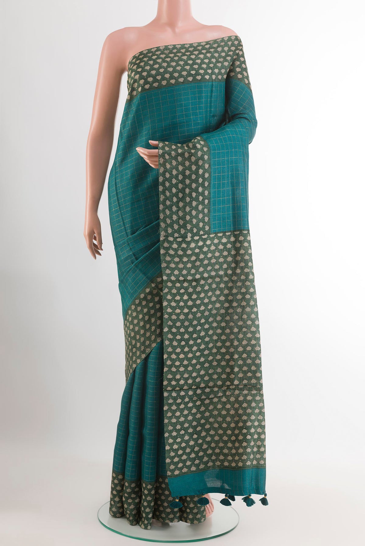 Teal Tussar Saree with Checked design on the body and Printed Border.  displayed on a mannequin