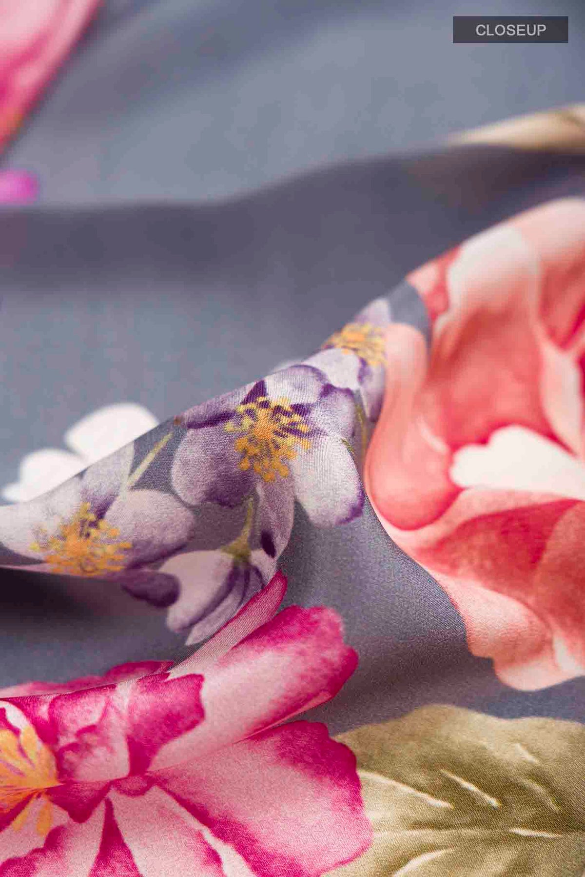 Close up of Grey Crepe Saree with Printed design on the body and Plain Border displaying folds