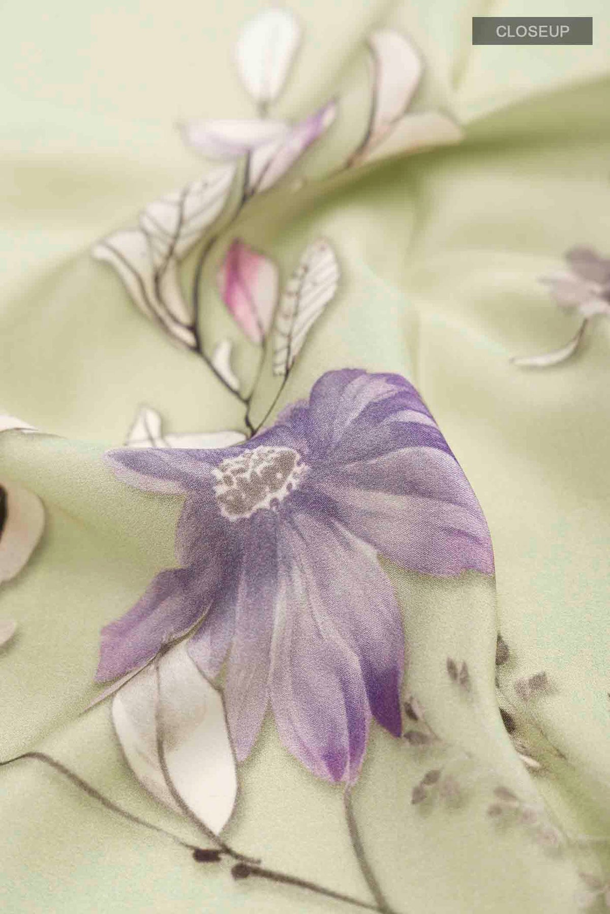 Close up of Green Mysore Crepe Saree with Printed design on the body and Plain Border displaying folds