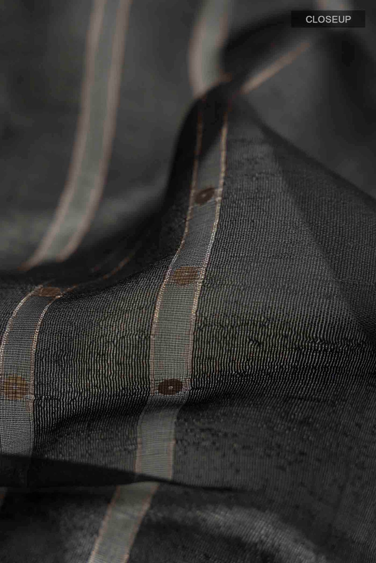 Close up of Black Tussar Silk Saree with Stripes on the body and Embroidery Border displaying folds