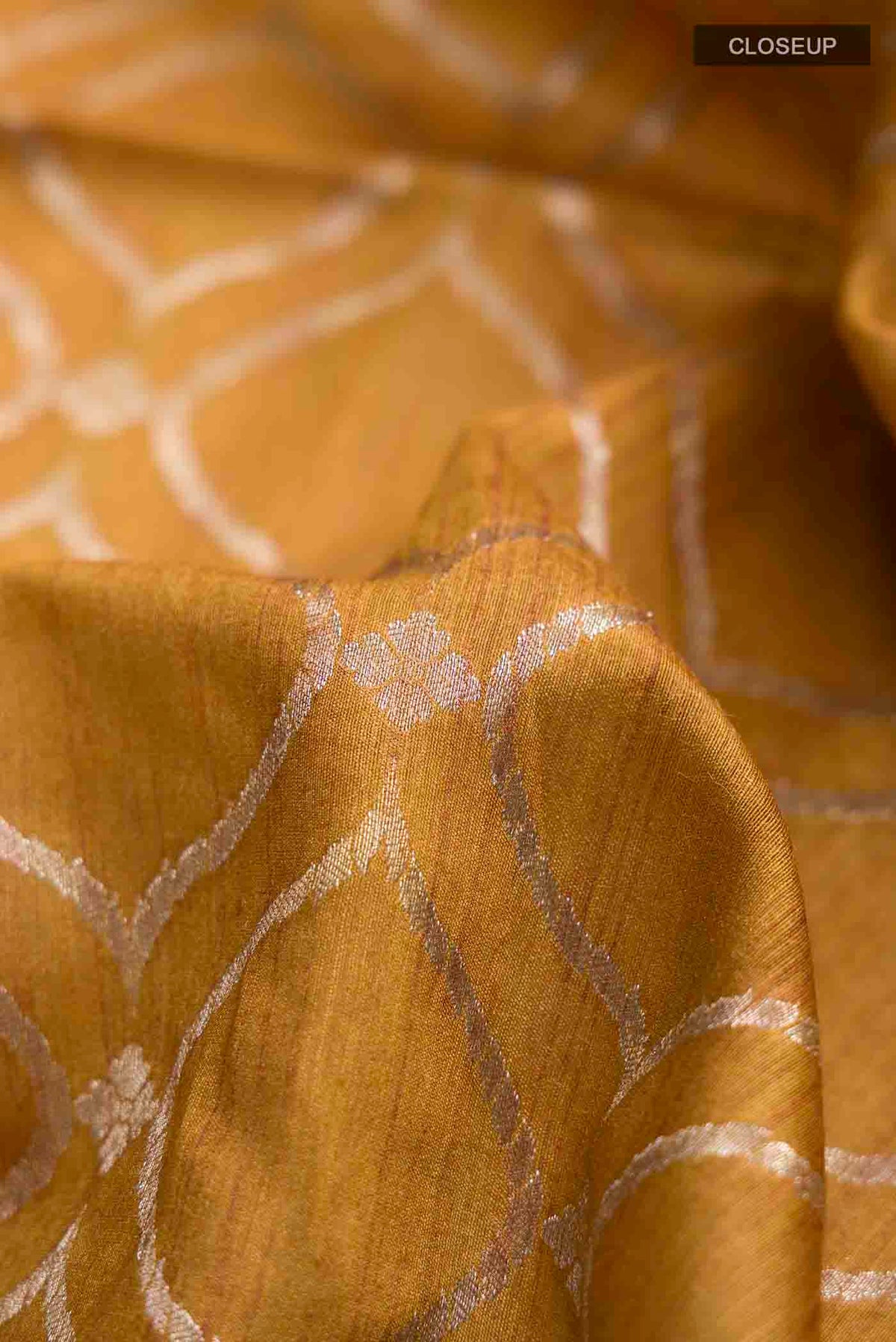 Close up of Mustard Tussar Silk Saree with Zari Butta on the body and Embroidery Border displaying folds