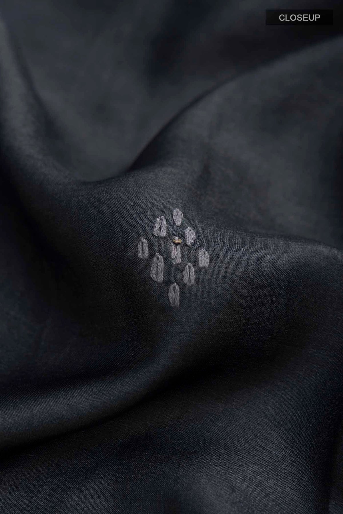 Close up of Black Tussar Silk Saree with Plain Body and Embroidery Border displaying folds