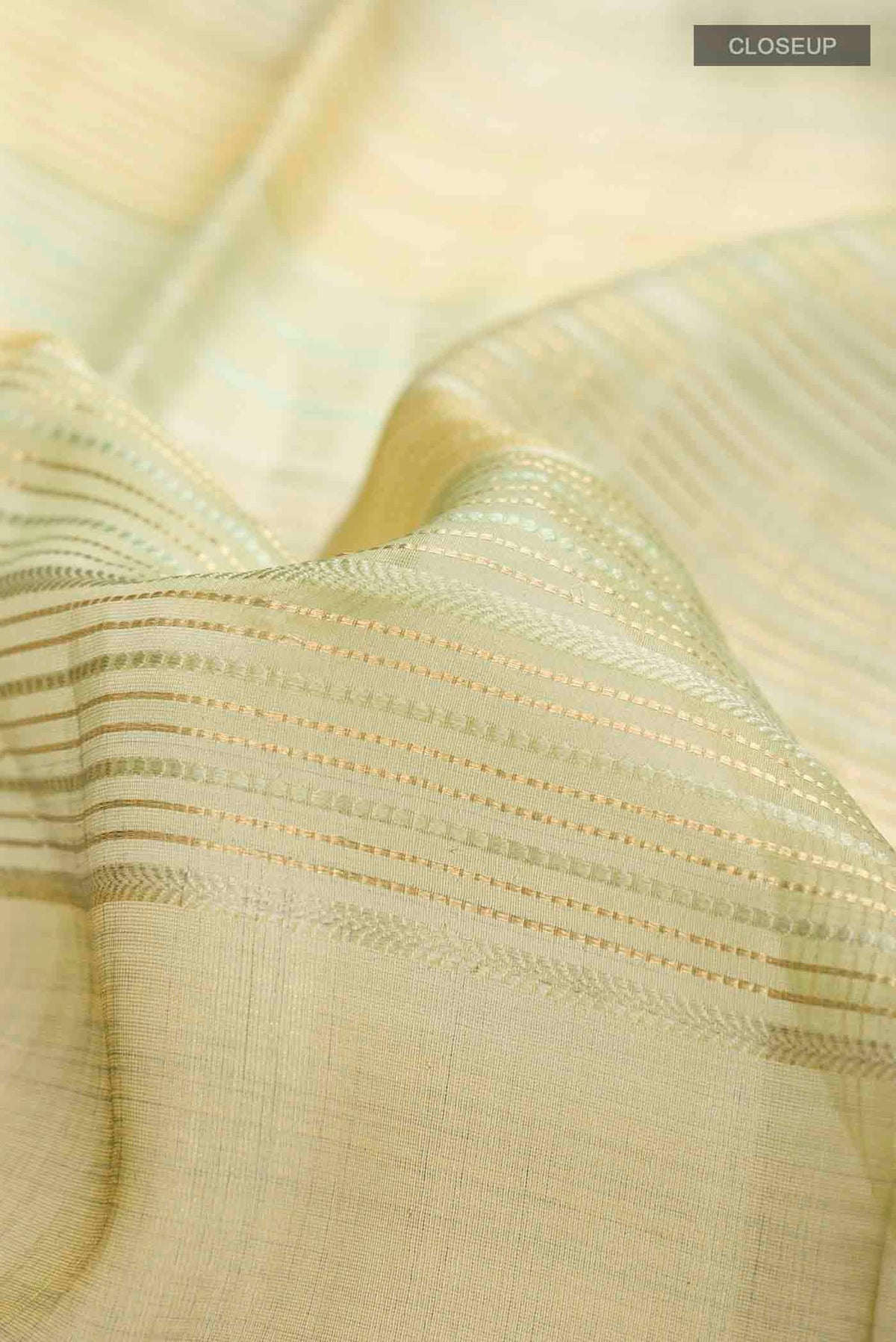 Close up of Green Tussar Silk Saree with Stripes on the body and Satin Border displaying folds