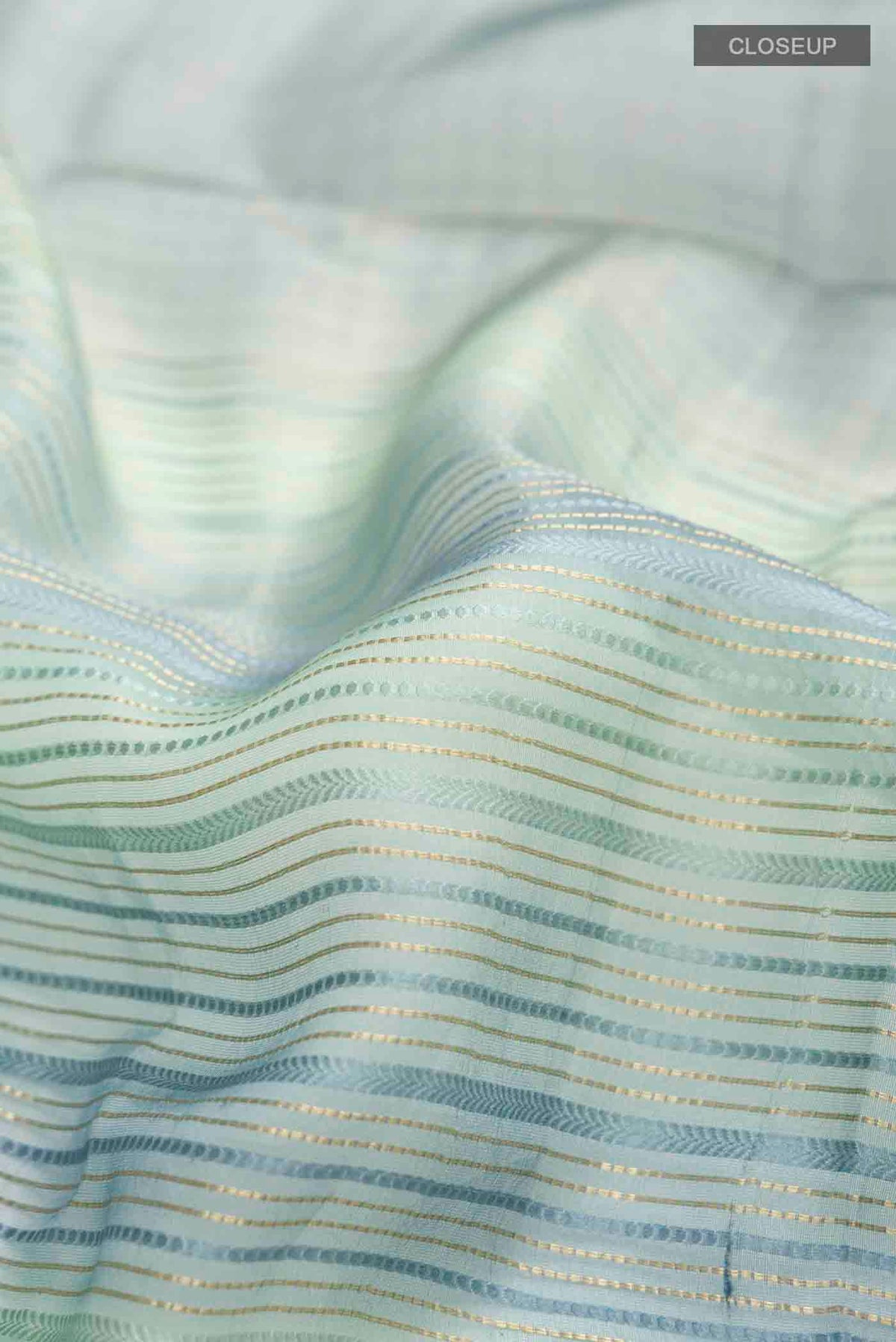 Close up of Blue Tussar Silk Saree with Stripes on the body and Zari Border displaying folds