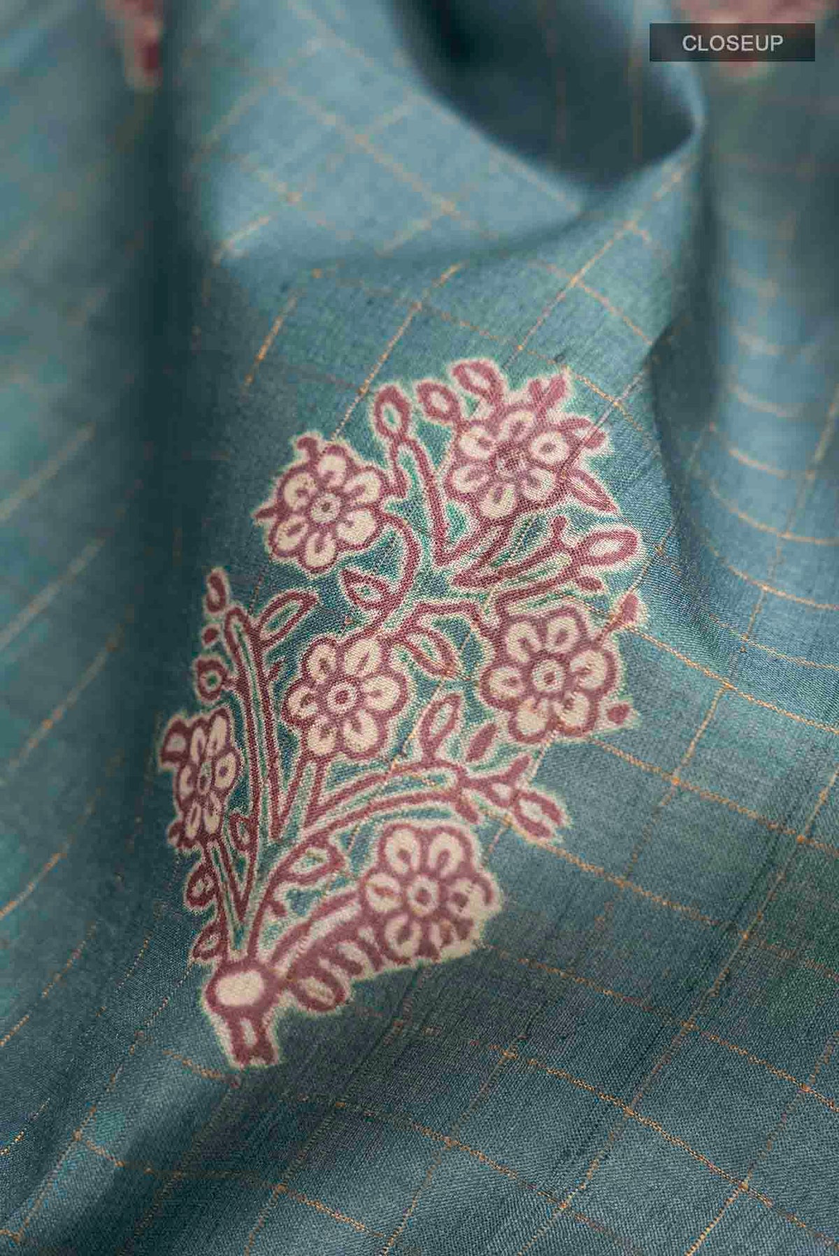 Close up of Blue Tussar Silk Saree with Checked design on the body and Printed Border displaying folds