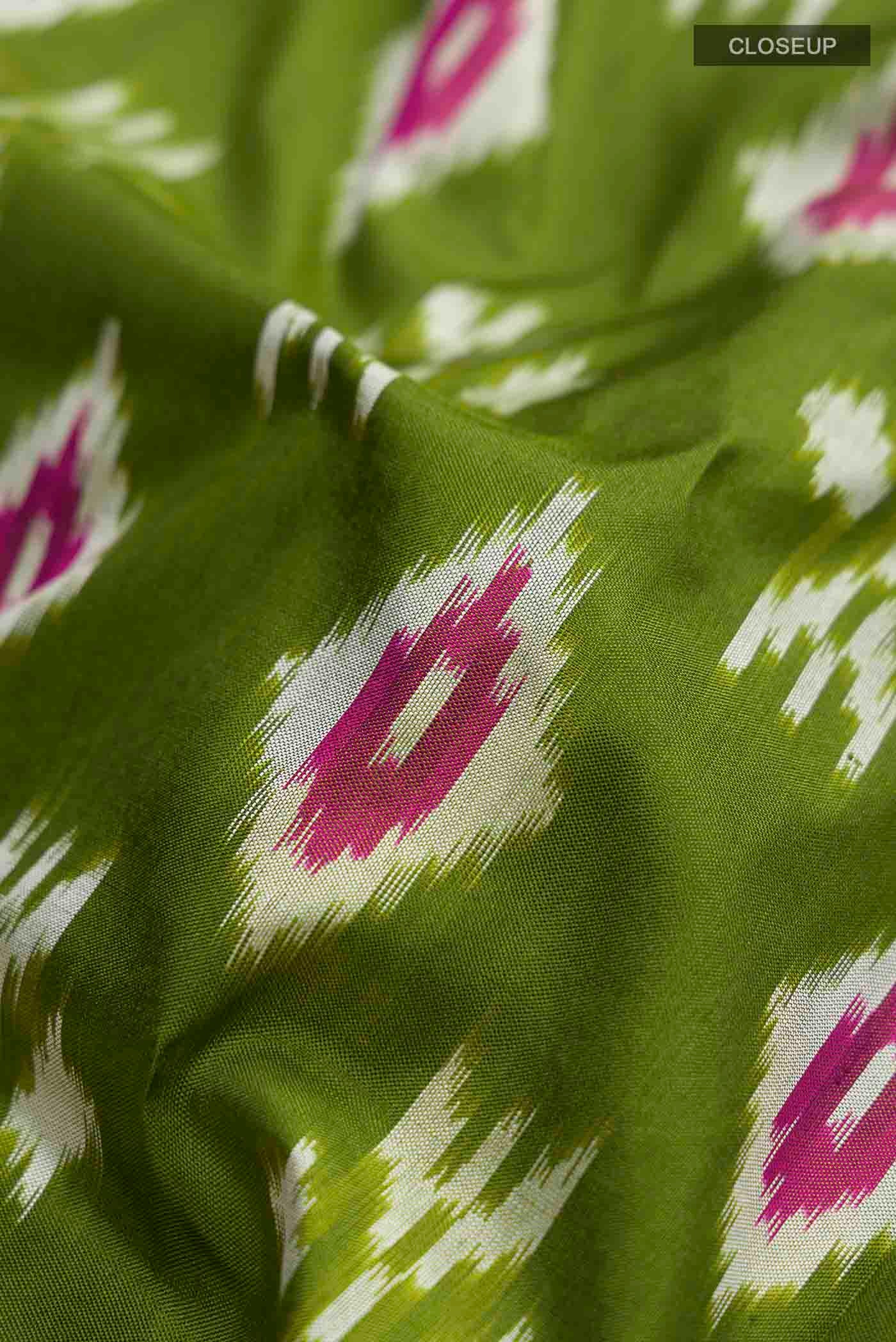 Close up of Green Pochampally Silk Saree with Ikat design on the body and Zari Border displaying folds