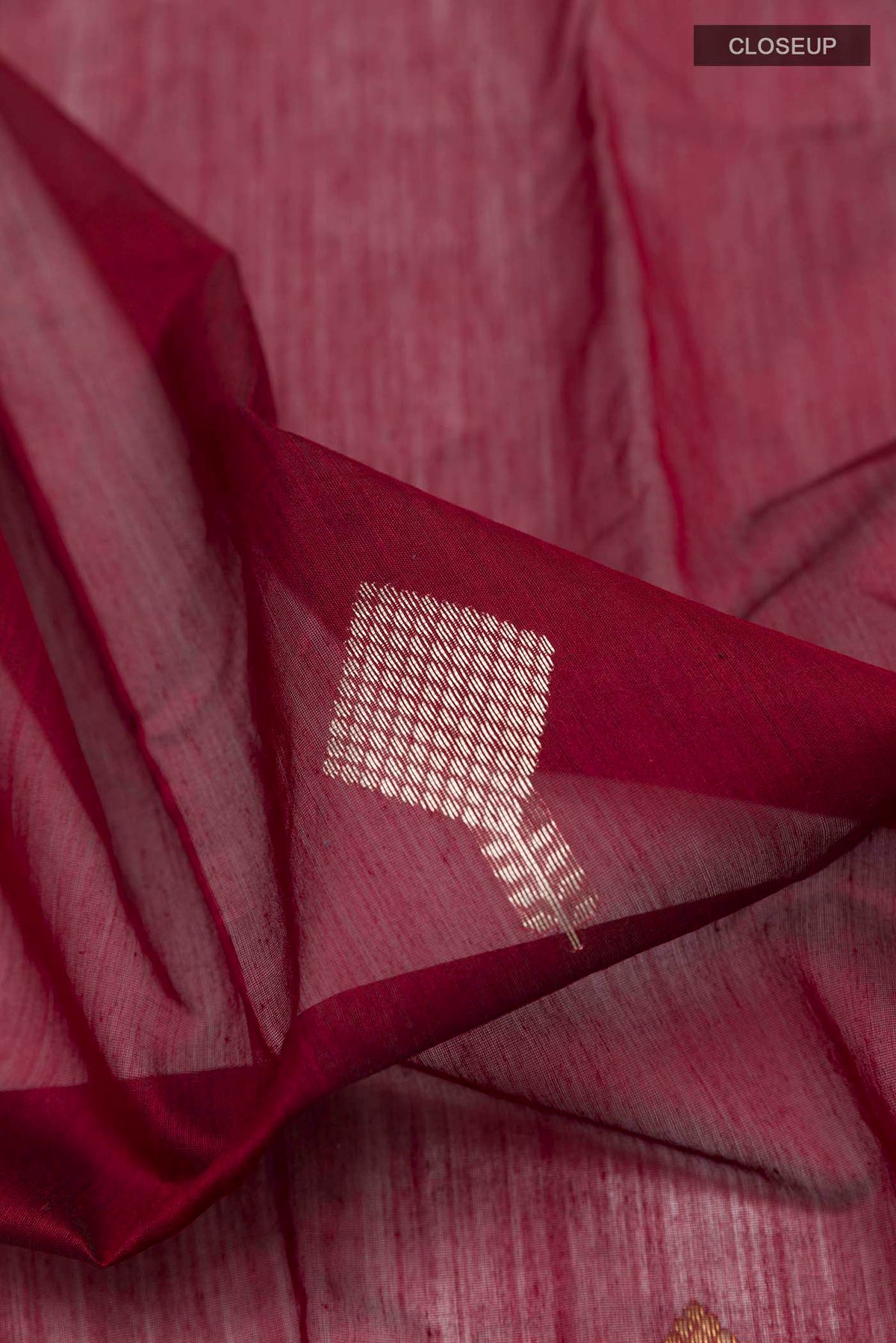 Close up of Maroon Chanderi Silk Cotton Saree with Zari Butta on the body and Zari Border displaying folds