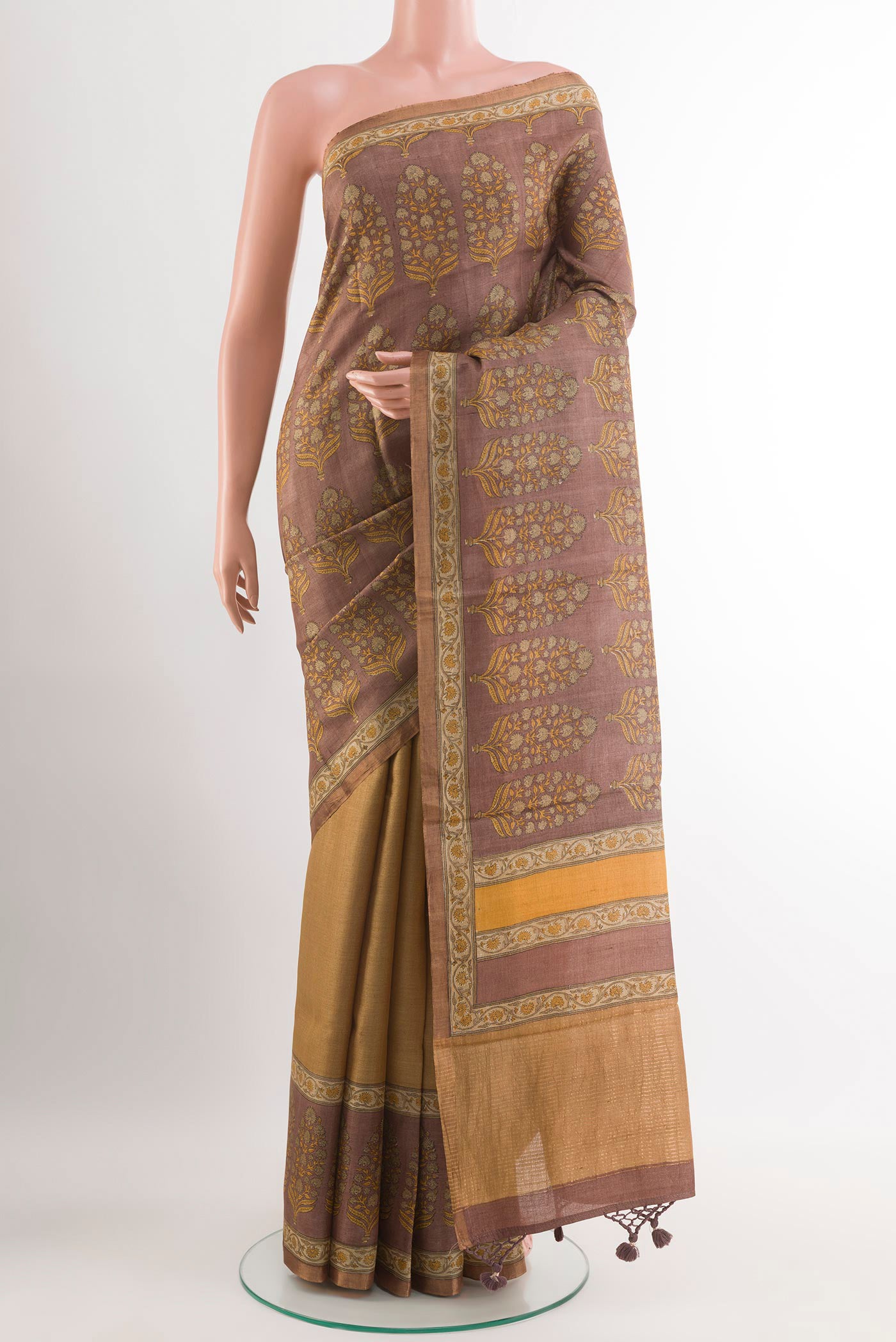 Beige Tussar Saree with Printed design on the body and Zari Border.  displayed on a mannequin