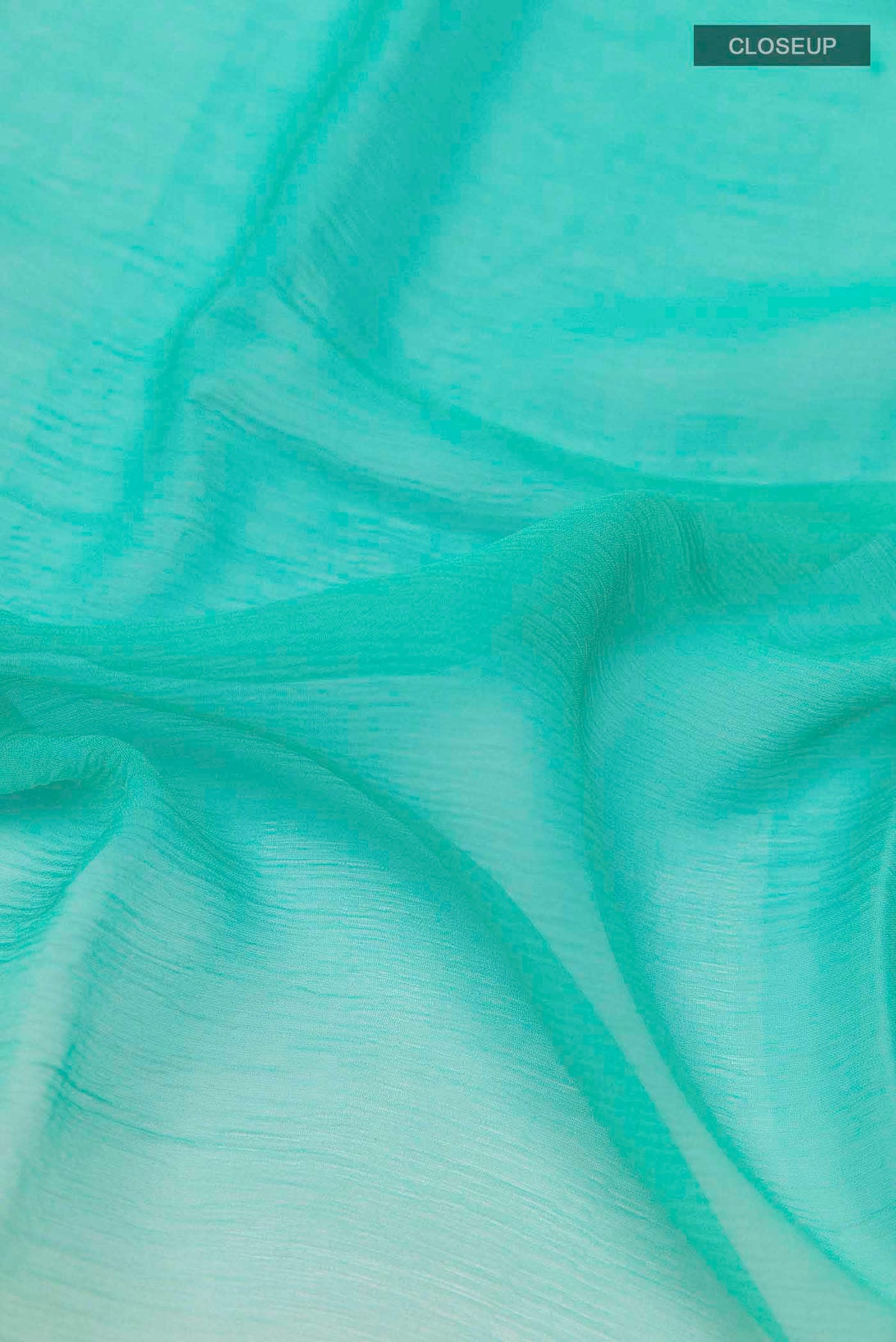 Close up of Sea Green Mysore Chiffon Saree with Printed design on the body and Zari Border displaying folds