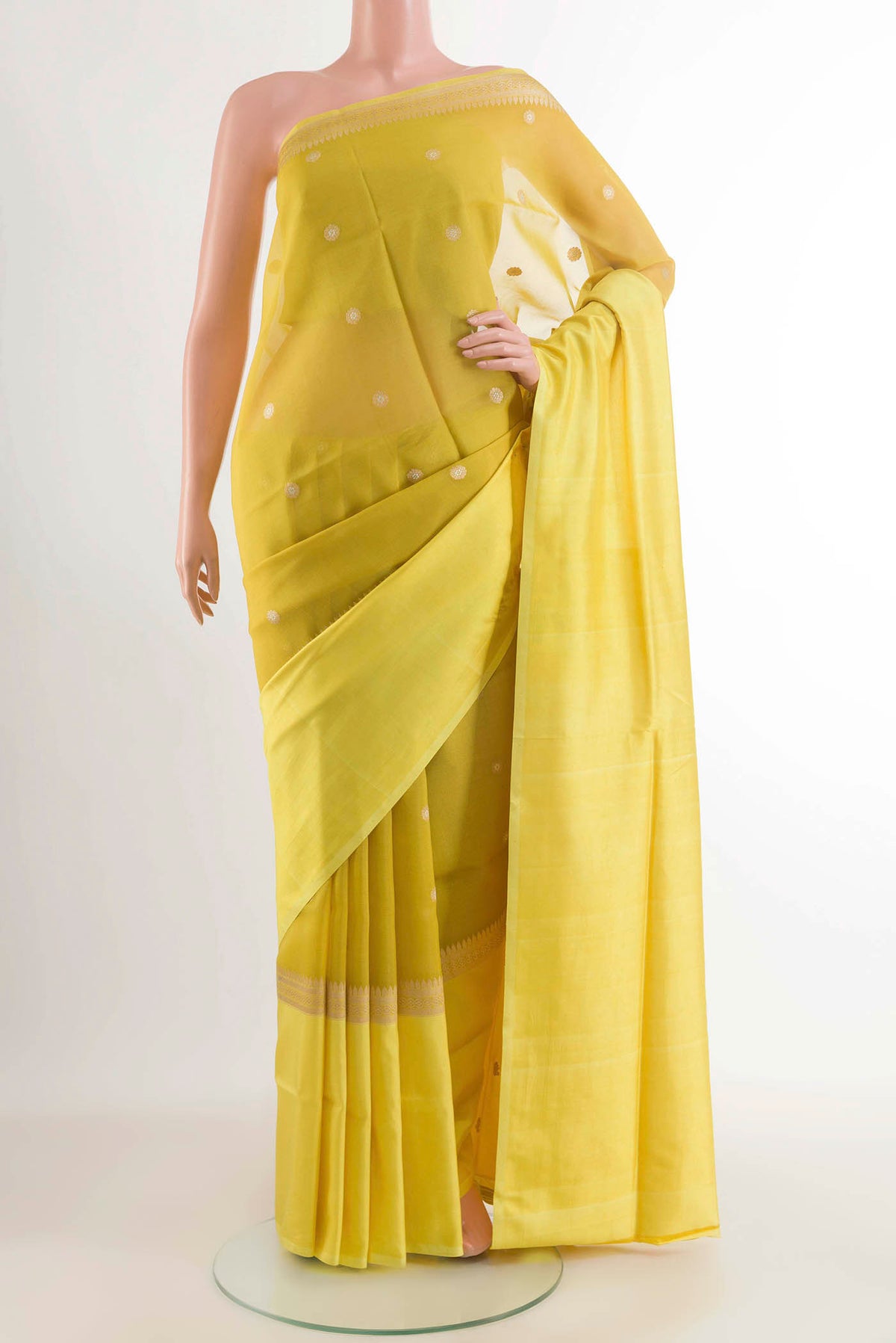 Yellow Banarasi Kora Silk Saree with Zari Butta on the body and Zari Border displayed on a mannequin