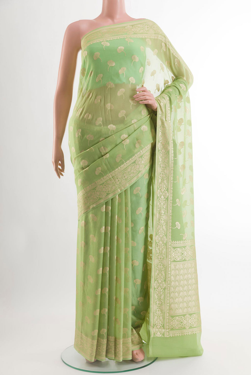 Green Chiffon Saree with Zari Butta on the body and Zari Border.  displayed on a mannequin
