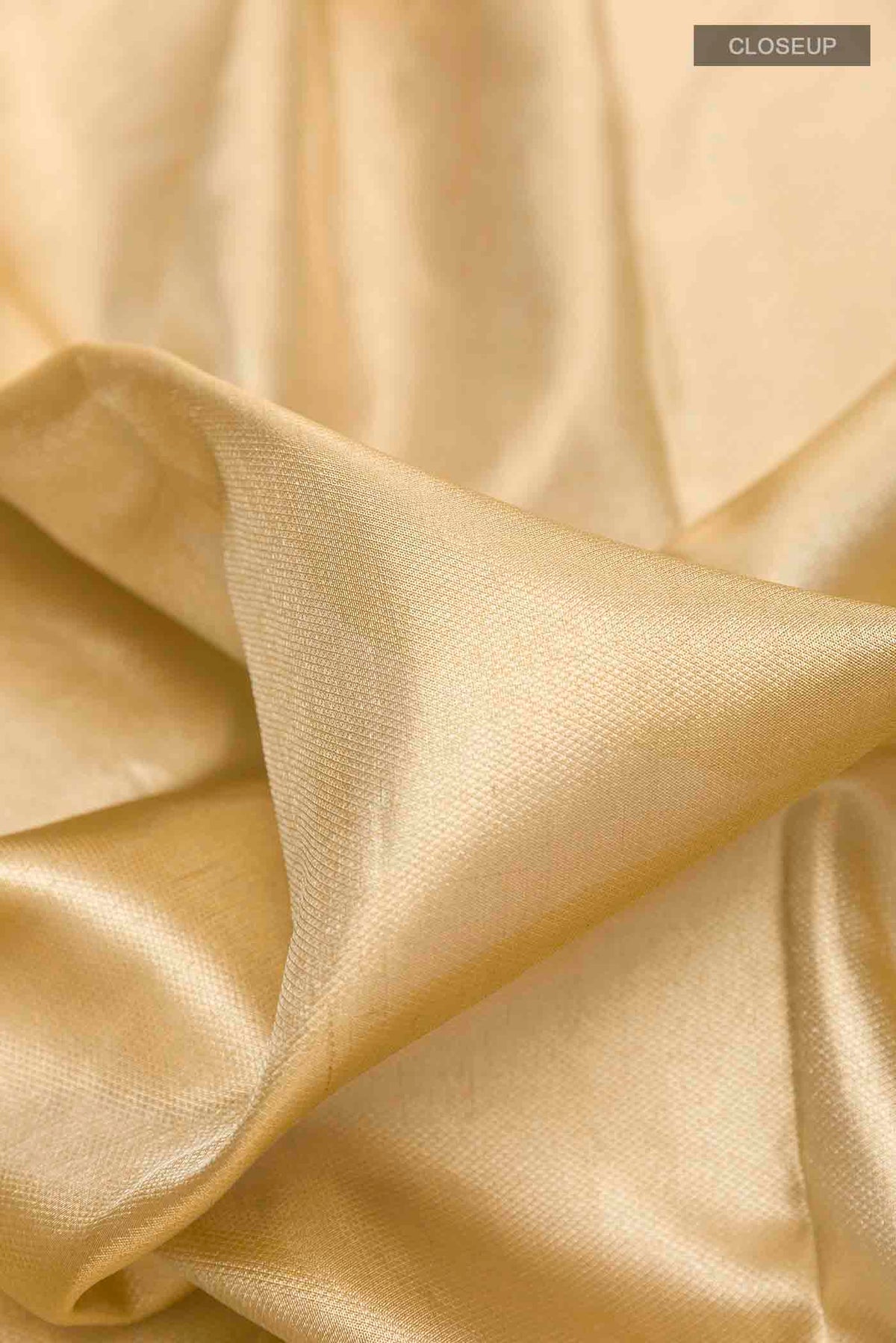 Close up of Golden Kanchipuram Tissue Silk Saree with Zari Brocade on the body and Zari Border displaying folds