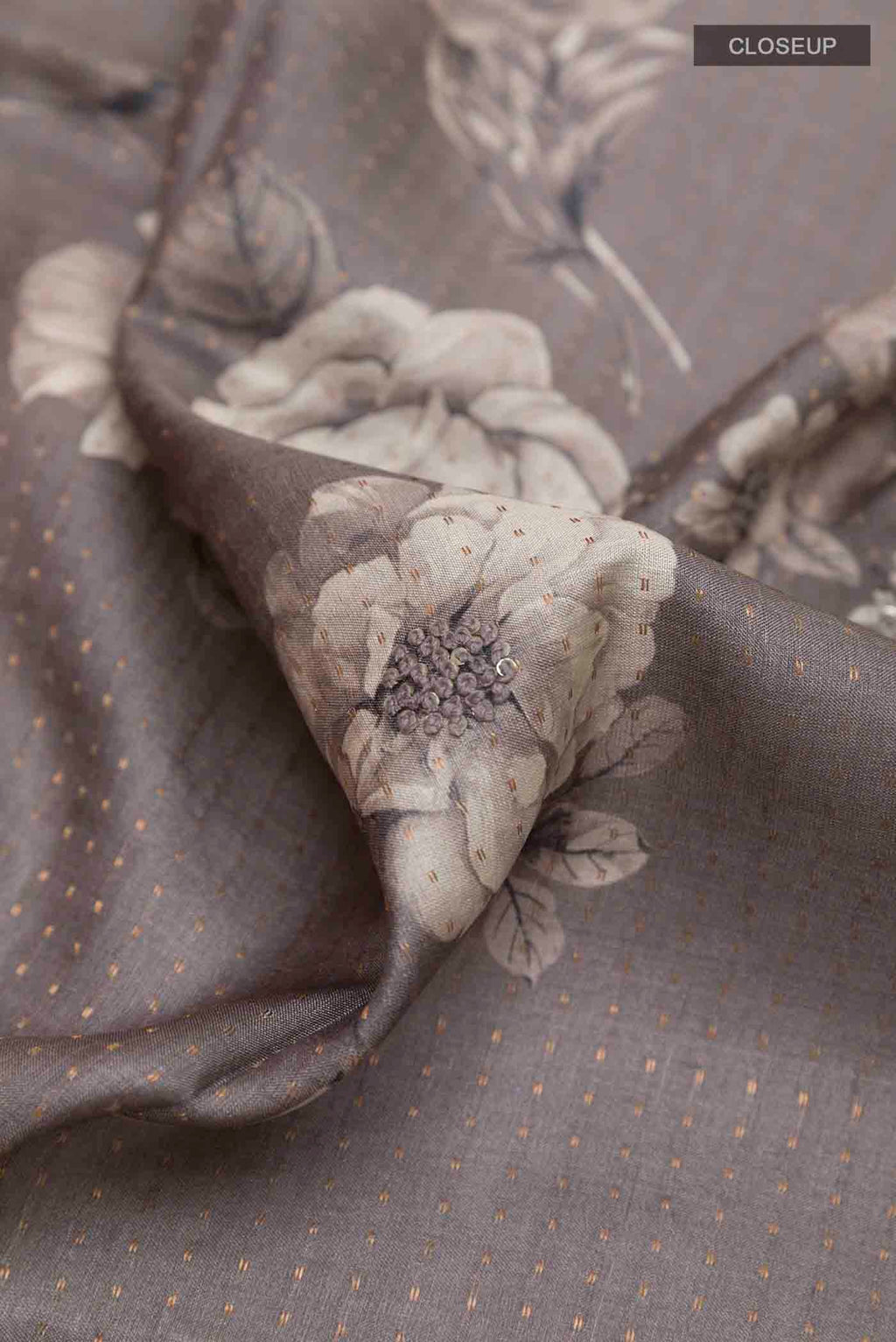 Close up of Grey Tussar Saree with Printed design on the body and Thread Border displaying folds