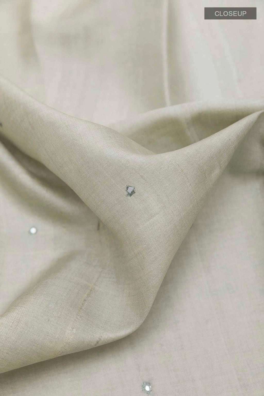 Close up of Grey Tussar Saree with Thread Butta on the body and Printed Border displaying folds