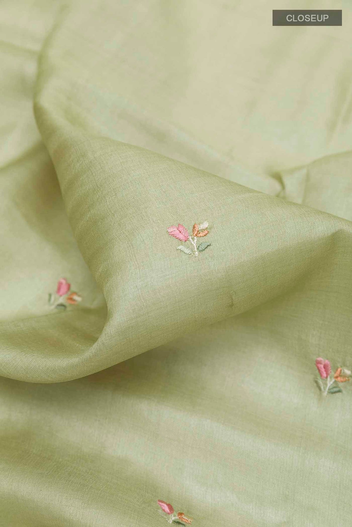 Close up of Sage Green Tussar Saree with Thread Butta on the body and Embroidery Border displaying folds
