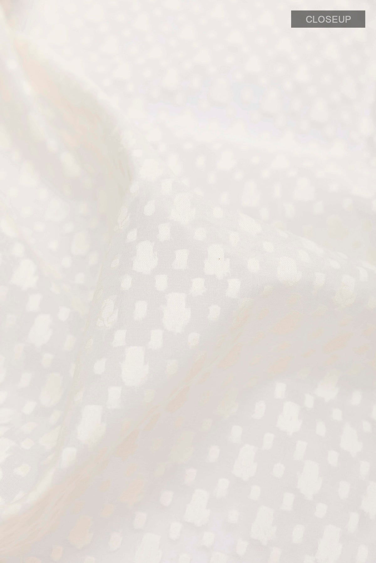 Close up of White Banarasi Kora Cotton Saree with Jacquard design on the body and Zari Border displaying folds