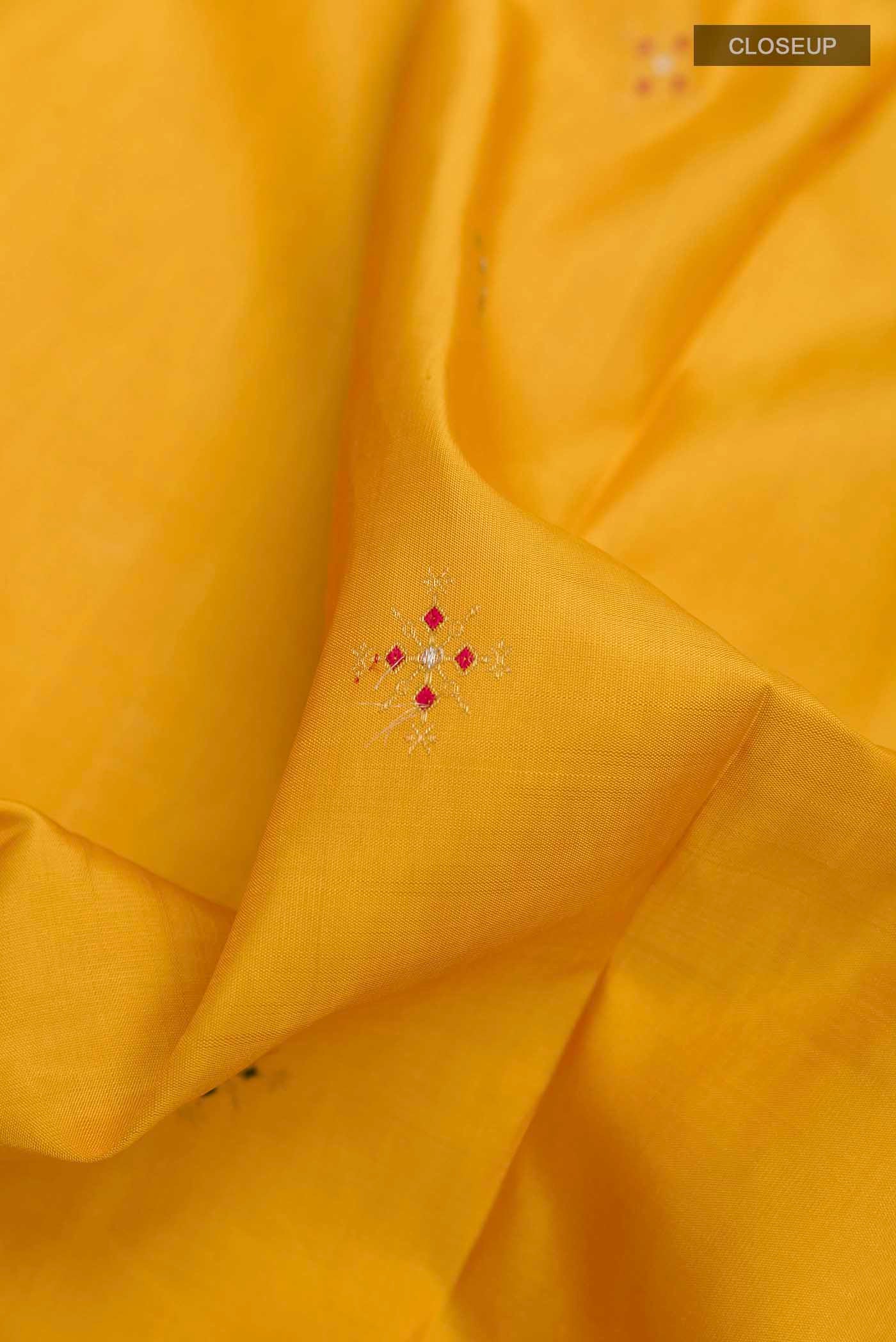 Close up of Mustard Kanchipuram Silk Saree with Zari Butta on the body and Zari Border displaying folds