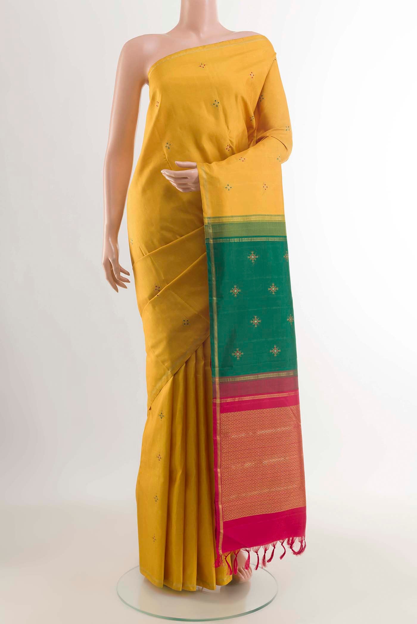 Mustard Kanchipuram Silk Saree with Zari Butta on the body and Zari Border displayed on a mannequin