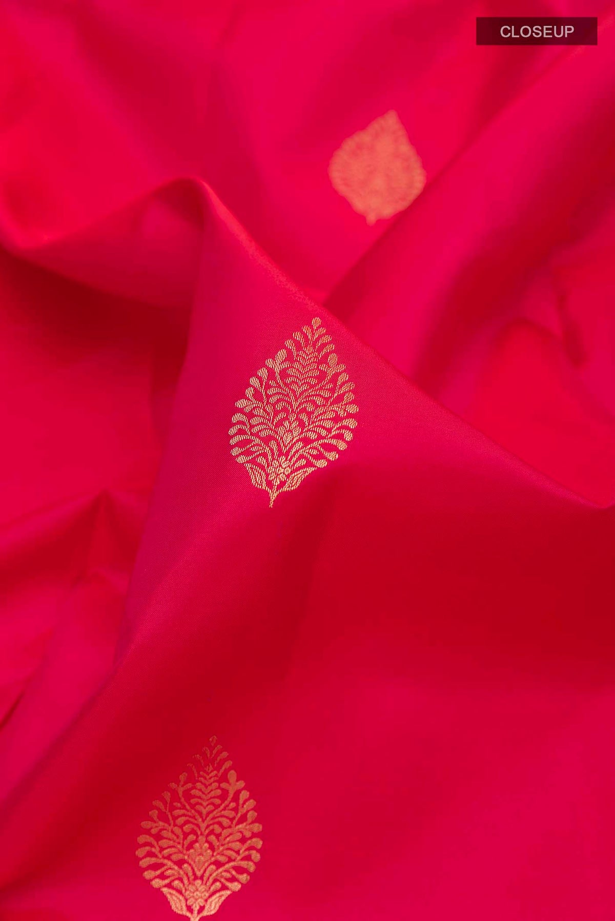 Close up of Red Soft Silk Saree with Zari Butta on the body and Zari Border displaying folds