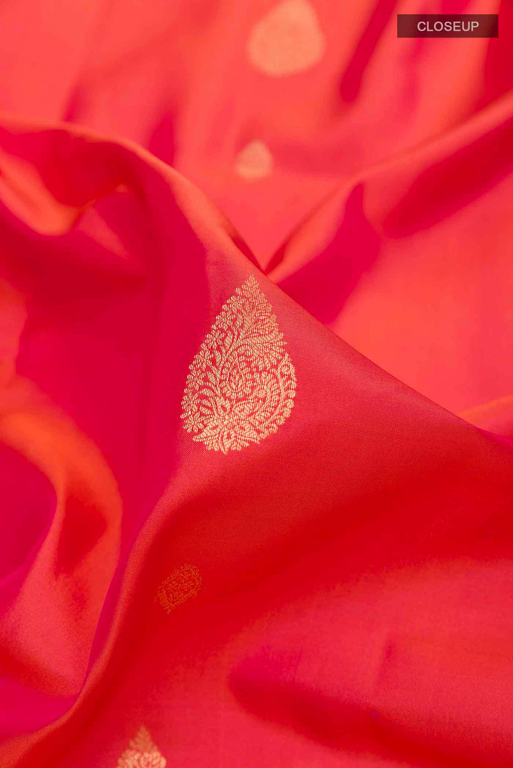 Close up of Peach Soft Silk Saree with Zari Butta on the body and Zari Border displaying folds