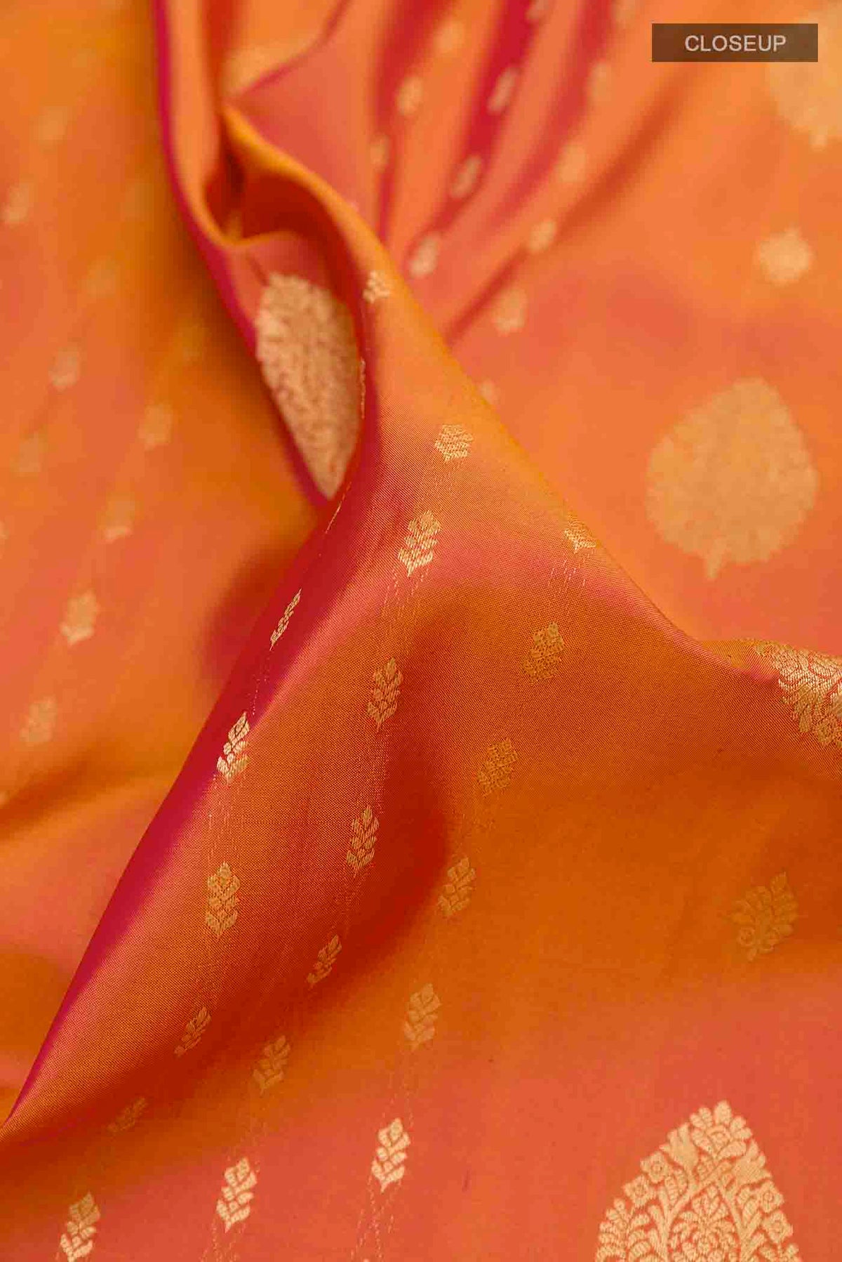Close up of Peach Dual Tone Soft Silk Saree with Zari Butta on the body and Zari Border displaying folds