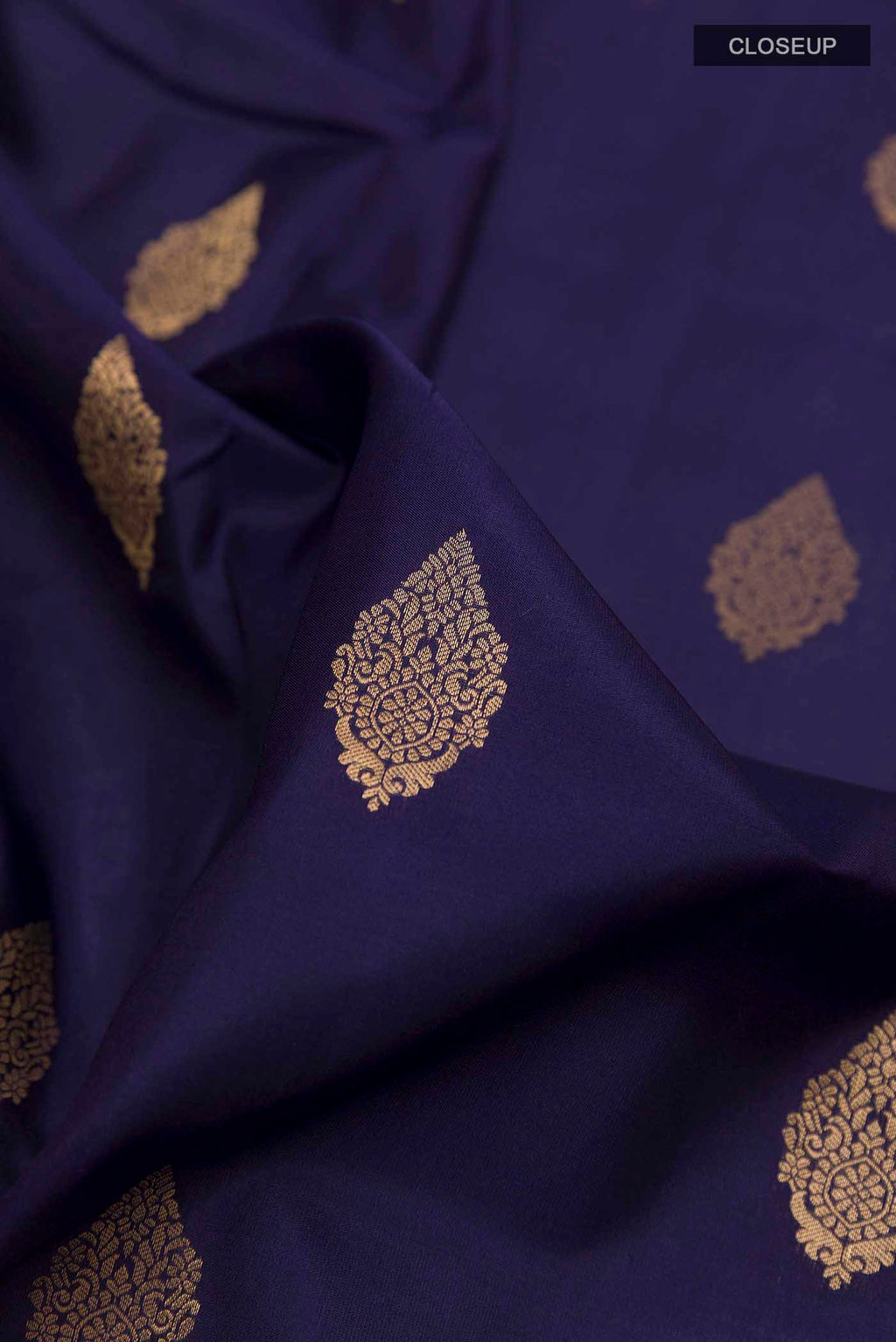 Close up of Navy Blue Soft Silk Saree with Zari Butta on the body and Zari Border displaying folds
