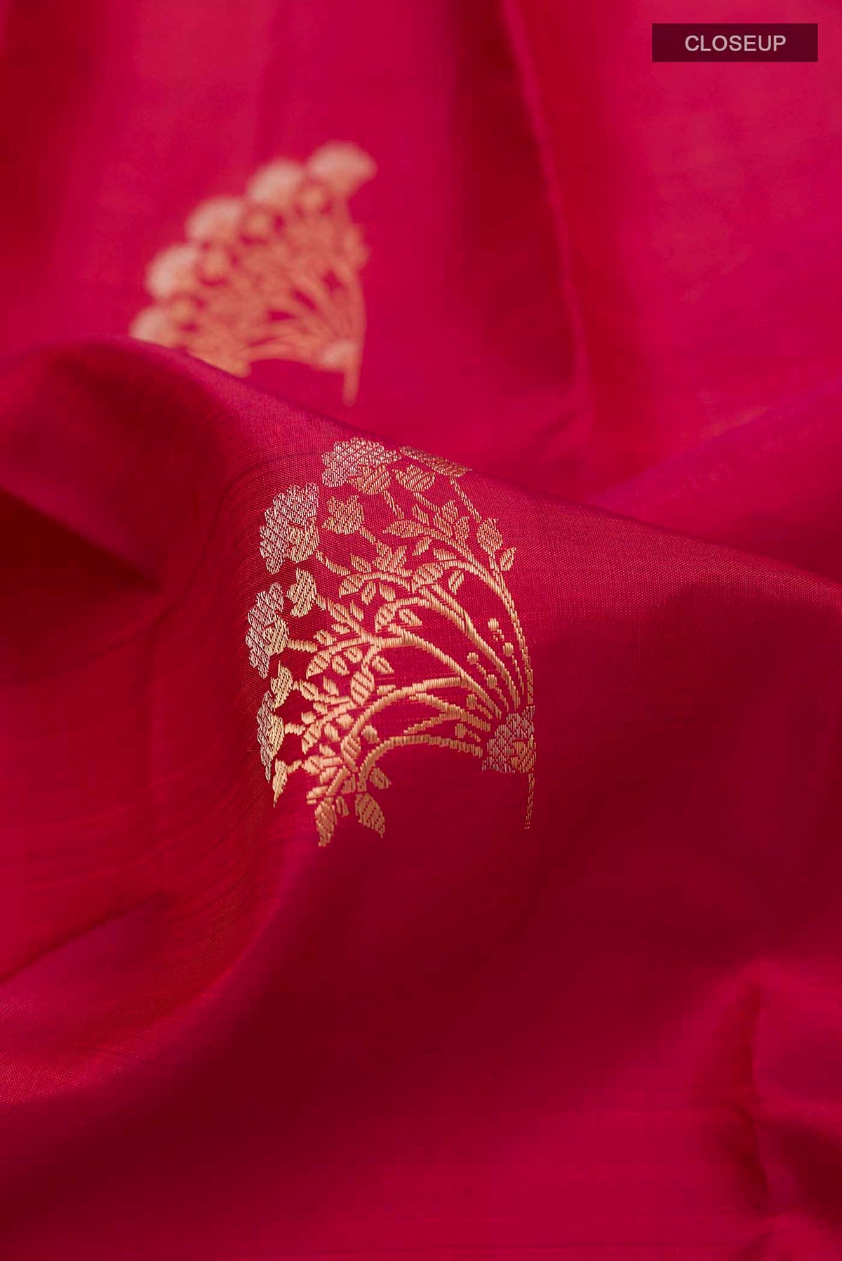 Close up of Maroon Kanchipuram Silk Saree with Zari Butta on the body and Zari Border displaying folds