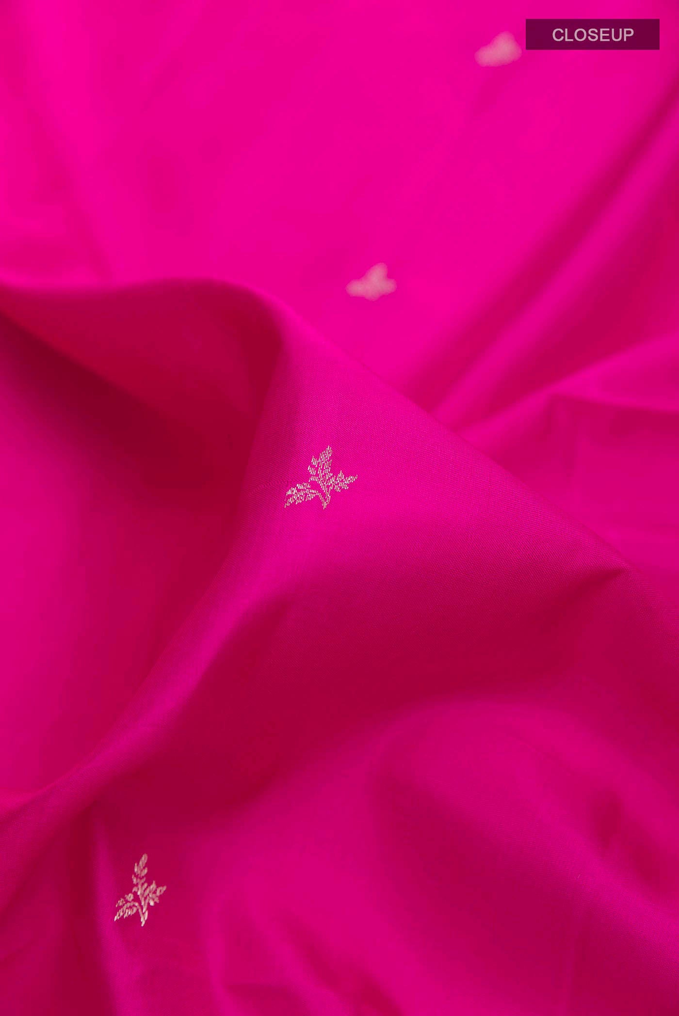 Close up of Pink Soft Silk Saree with Zari Butta on the body and Zari Border displaying folds