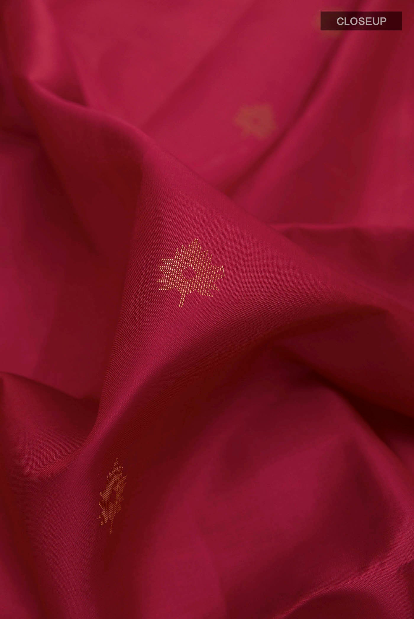 Close up of Maroon Soft Silk Saree with Zari Butta on the body and Zari Border displaying folds