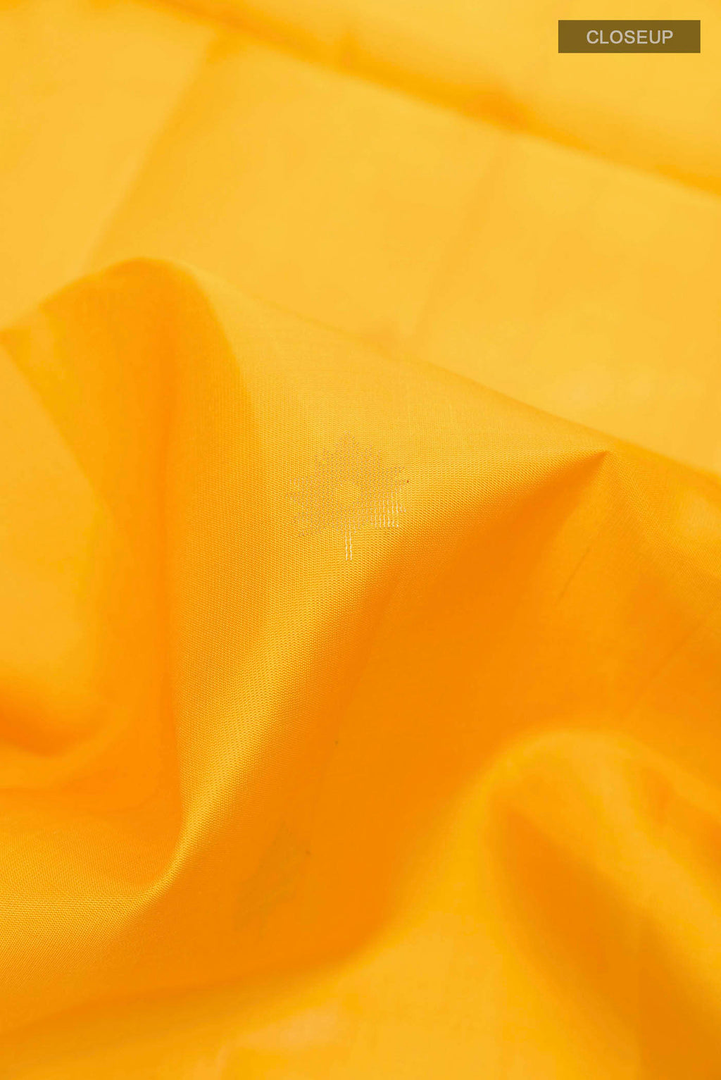 Close up of Yellow Soft Silk Saree with Zari Butta on the body and Zari Border displaying folds