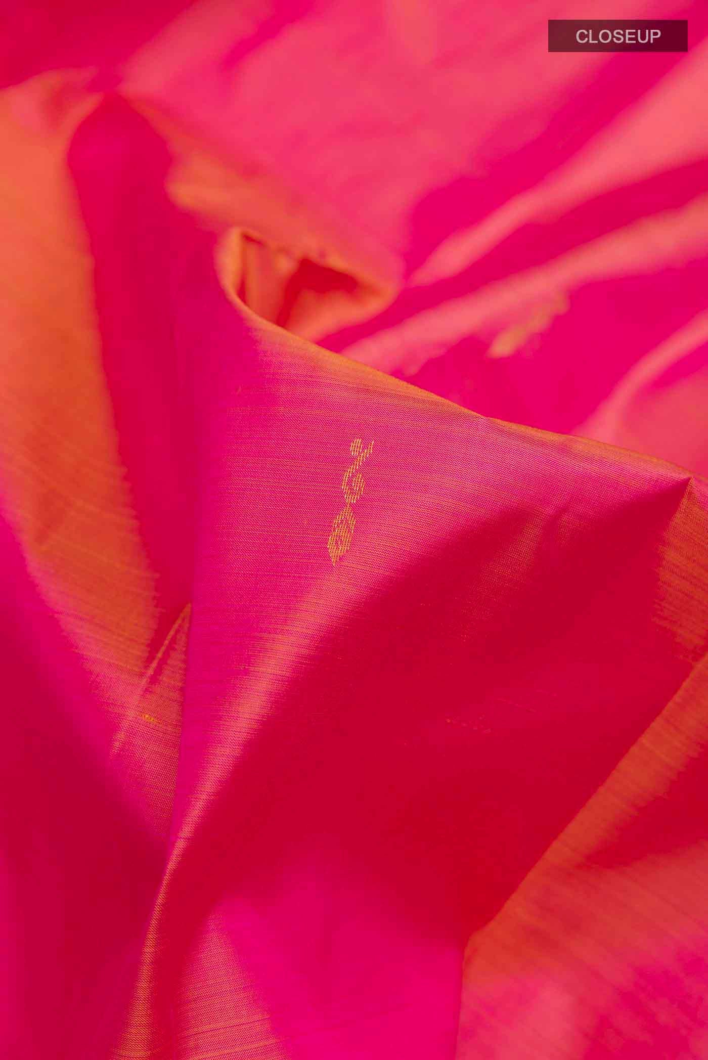 Close up of Pink Kanchipuram Silk Saree with Zari Butta on the body and Zari Border displaying folds