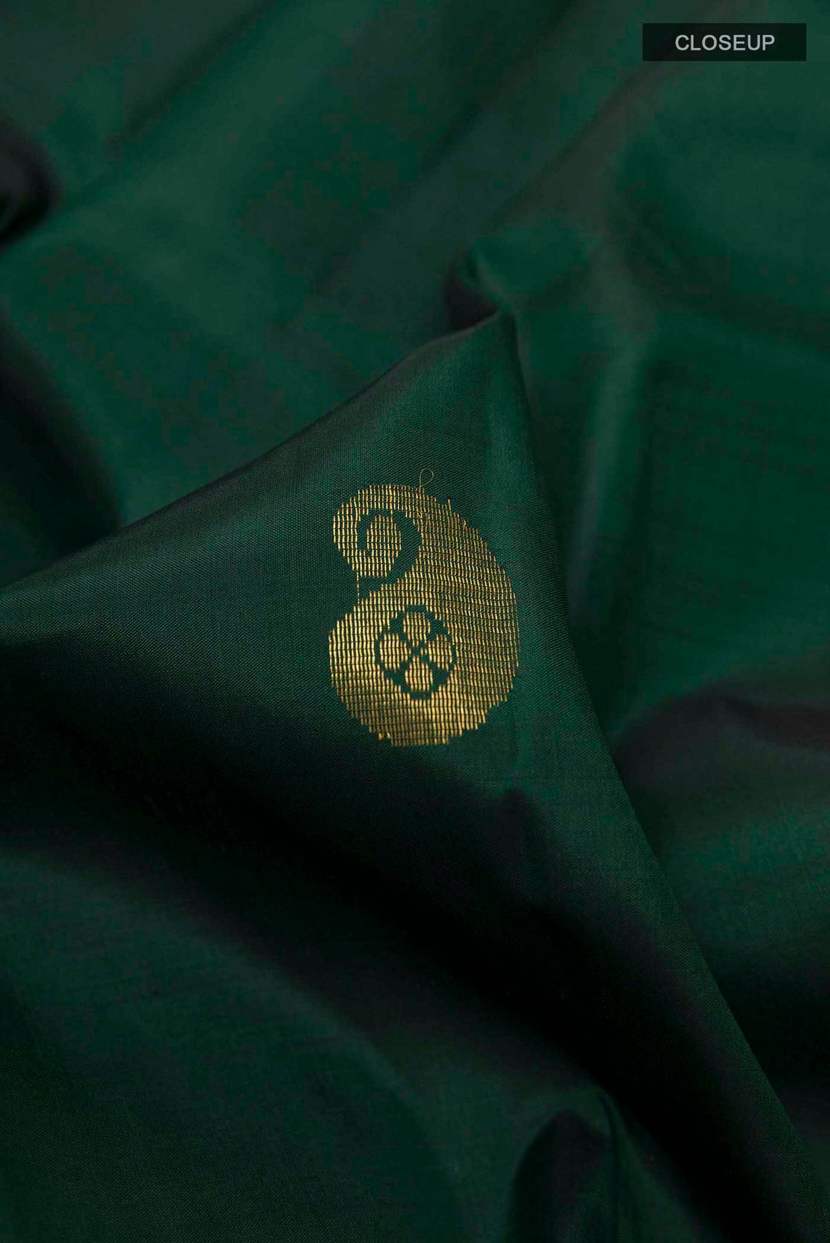 Close up of Bottle Green Kanchipuram Silk Saree with Zari Butta on the body and Zari Border displaying folds