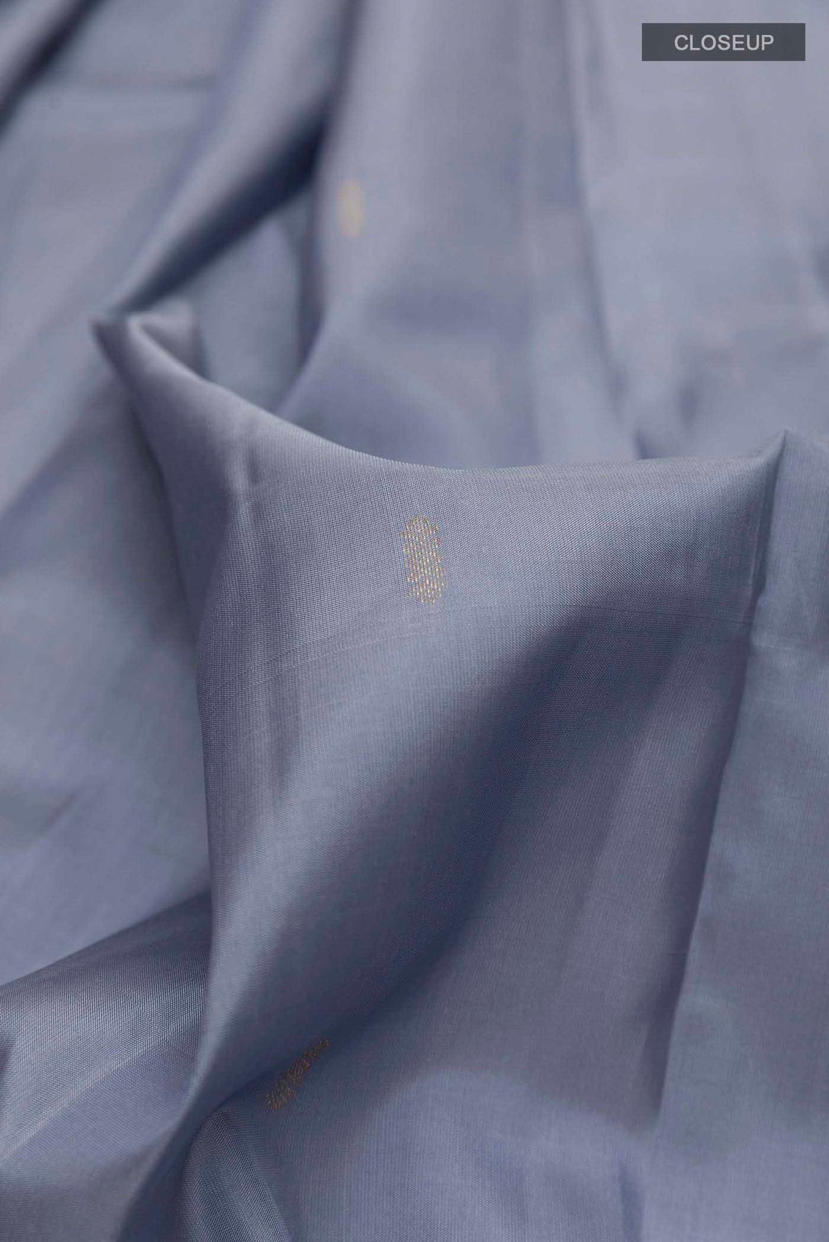 Close up of Grey Kanchipuram Silk Saree with Zari Butta on the body and Zari Border displaying folds