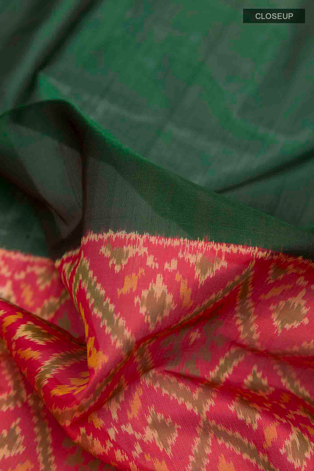 Close up of Green Rajkot Patola Silk Saree with Plain Body and Zari Border displaying folds