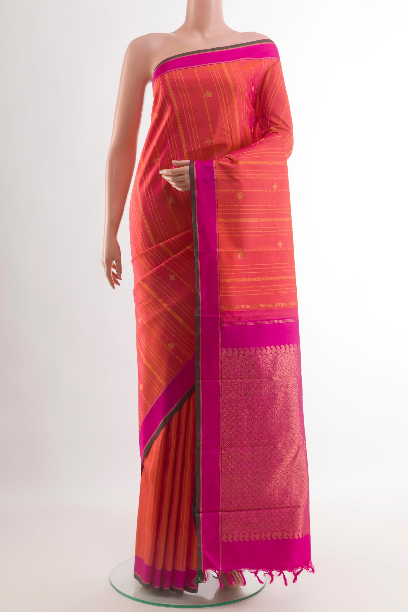 Brick Orange Kanjivaram Silk Saree with Zari Butta on the body and Plain Border.  displayed on a mannequin