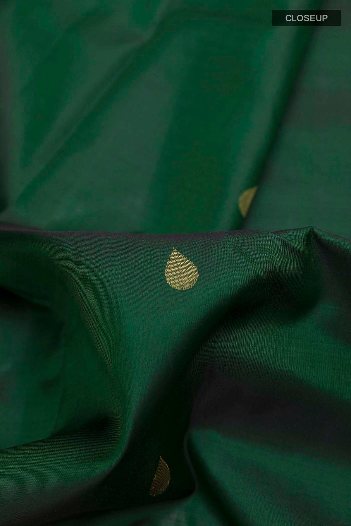 Close up of Bottle Green Kanchipuram Silk Saree with Zari Brocade on the body and Zari Border displaying folds