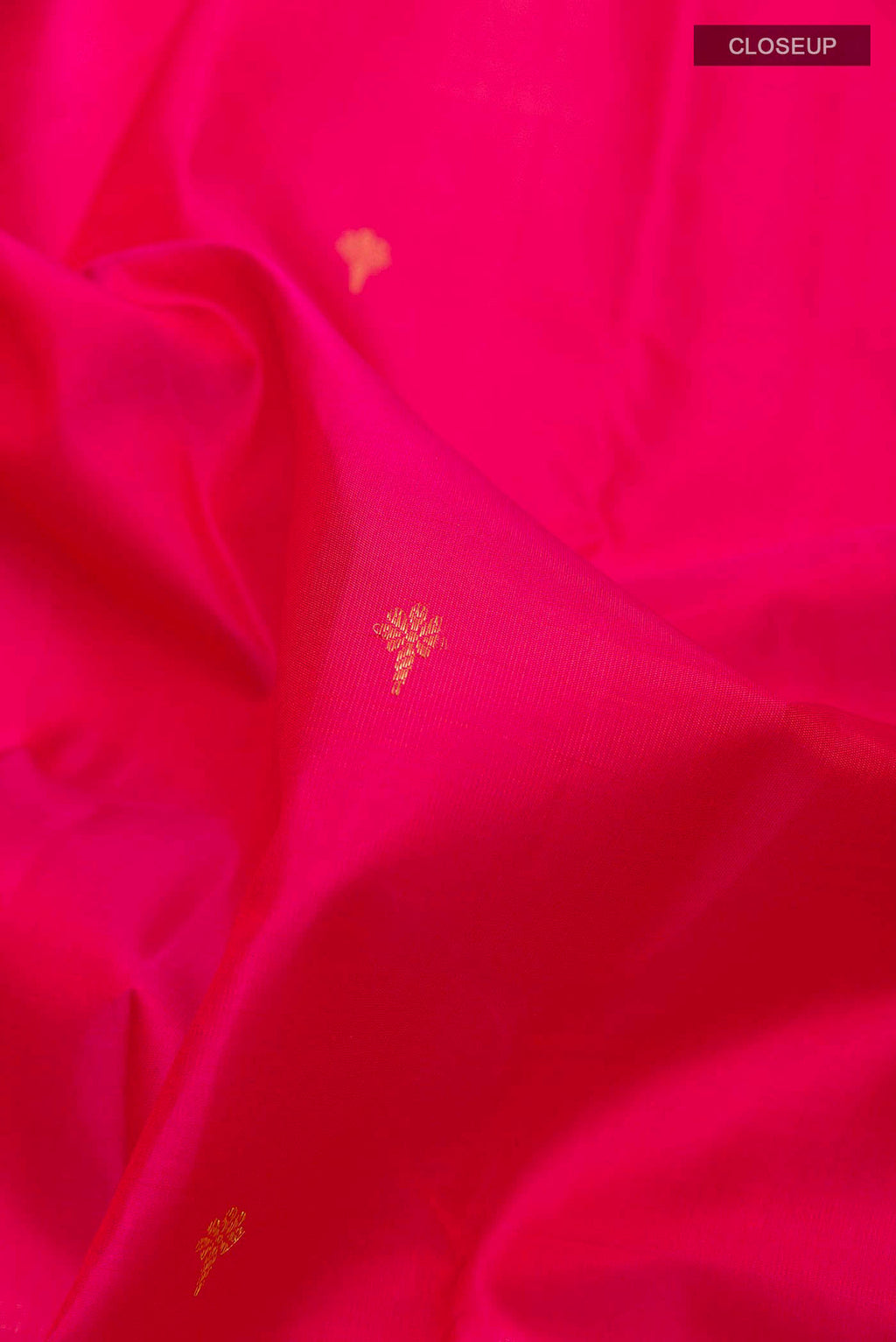 Close up of Pink Kanchipuram Silk Saree with Zari Butta on the body and Zari Border displaying folds