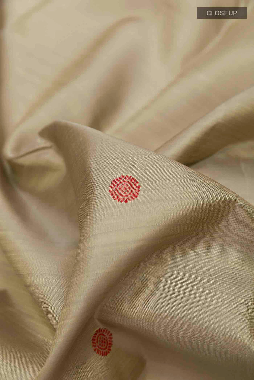 Close up of Beige Kanchipuram Silk Saree with Thread Butta on the body and Thread Border displaying folds