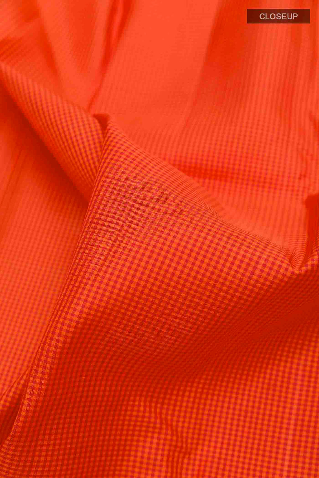 Close up of Orange Kanchipuram Silk Saree with Checked design on the body and Without Border displaying folds