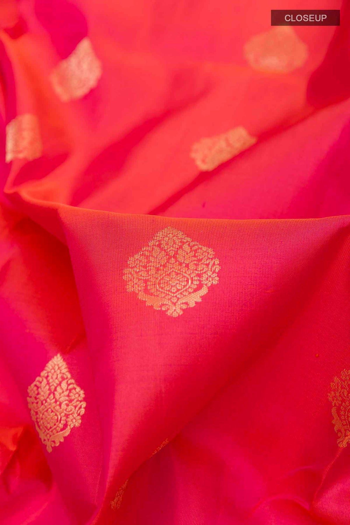 Close up of Pink Dual Tone Soft Silk Saree with Zari Butta on the body and Zari Border displaying folds