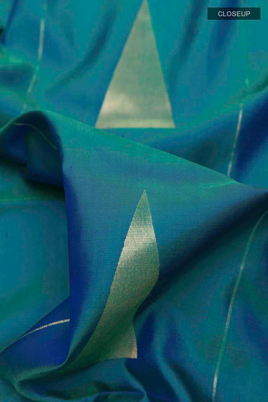 Close up of Peacock Blue Soft Silk Saree with Zari Butta on the body and Zari Border displaying folds