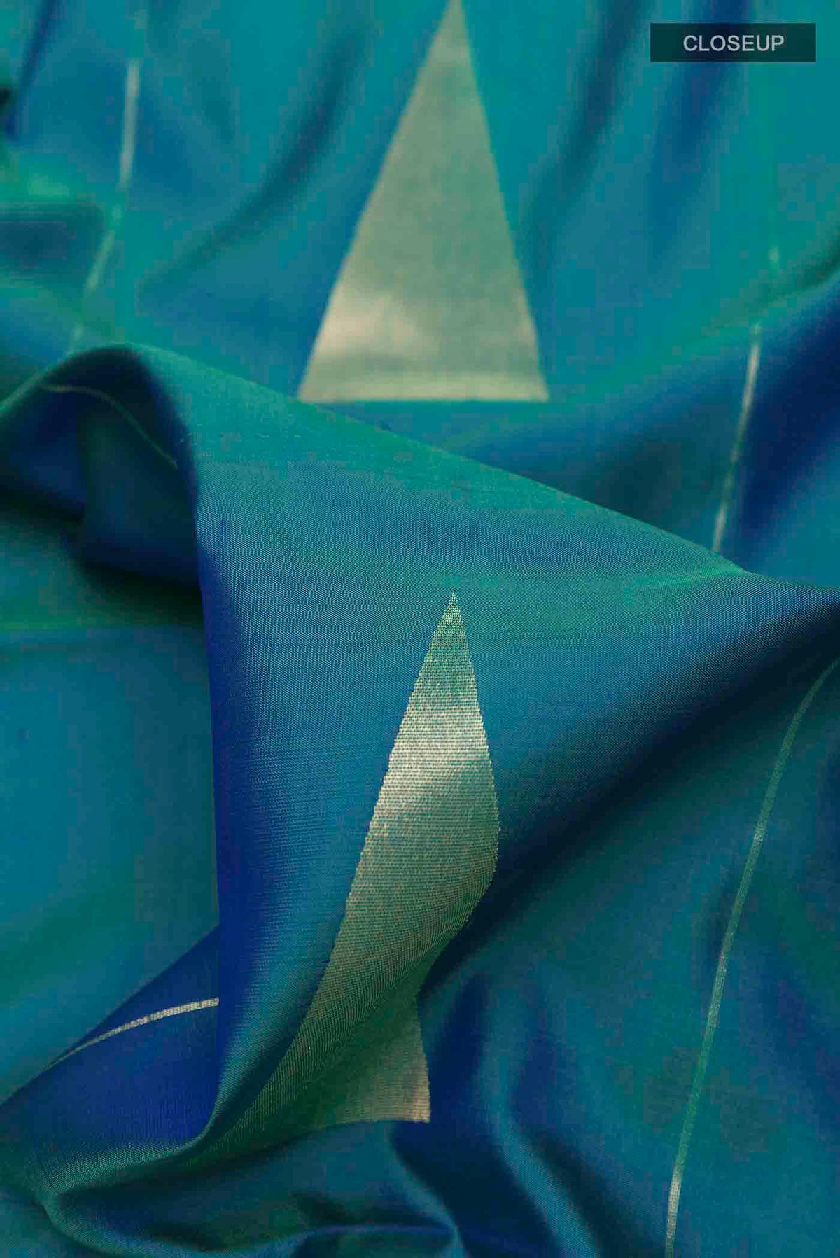 Close up of Peacock Blue Soft Silk Saree with Zari Butta on the body and Zari Border displaying folds