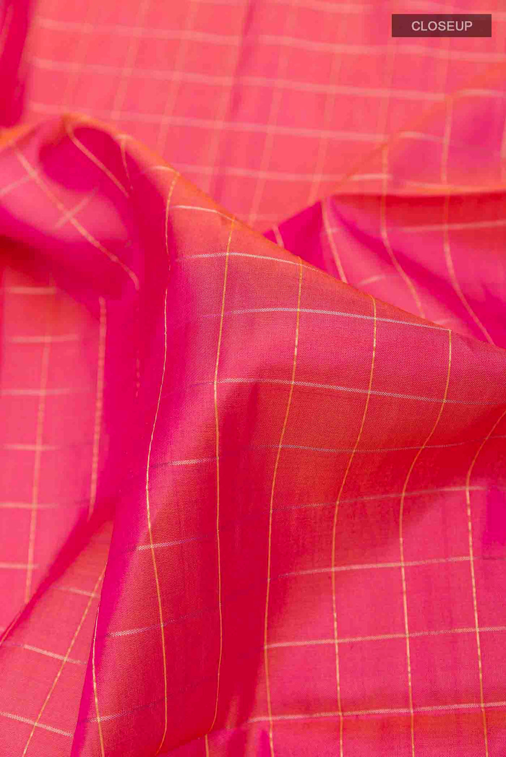 Close up of Peach Soft Silk Saree with Checked design on the body and Zari Border displaying folds