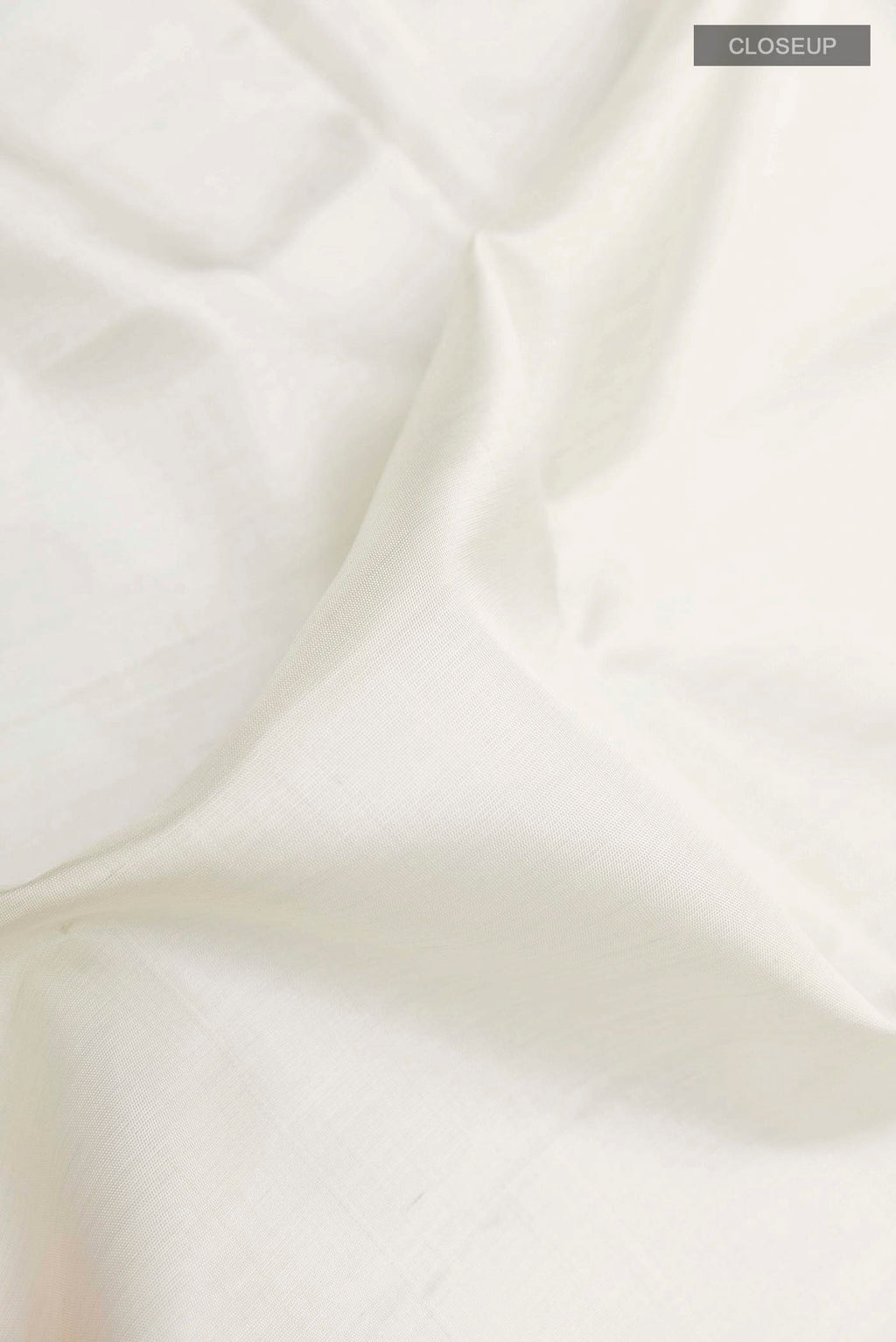 Close up of Off White Soft Silk Saree with Plain Body and Zari Border displaying folds